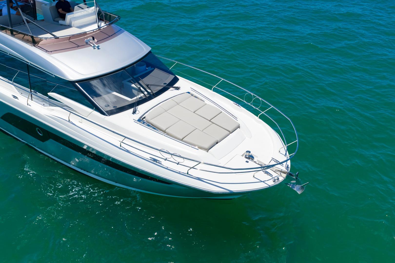 Luxury 2022 Prestige 520 yacht cruising on clear blue water.
