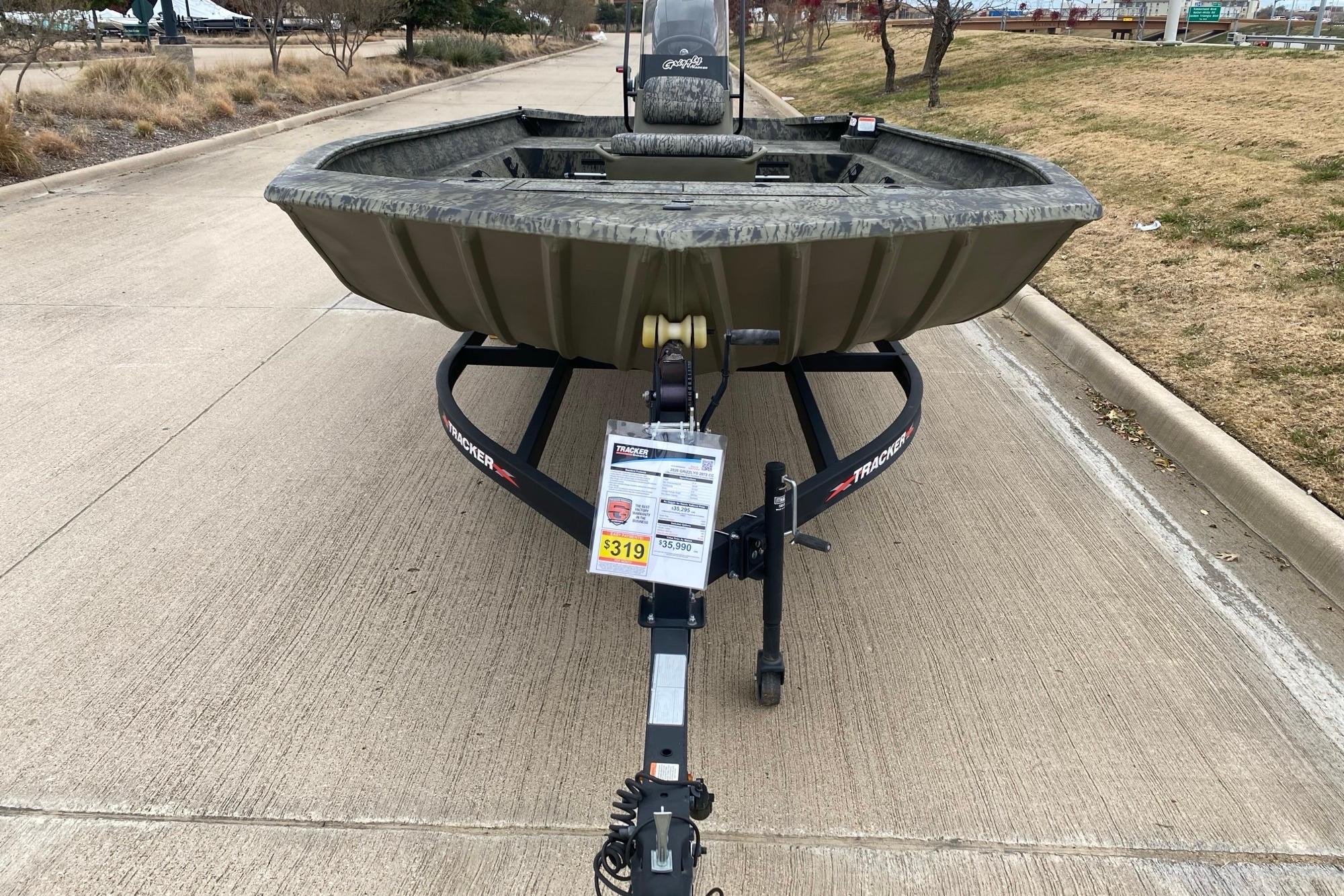 2026 Tracker Grizzly 2072 CC boat on trailer, parked on a concrete road.