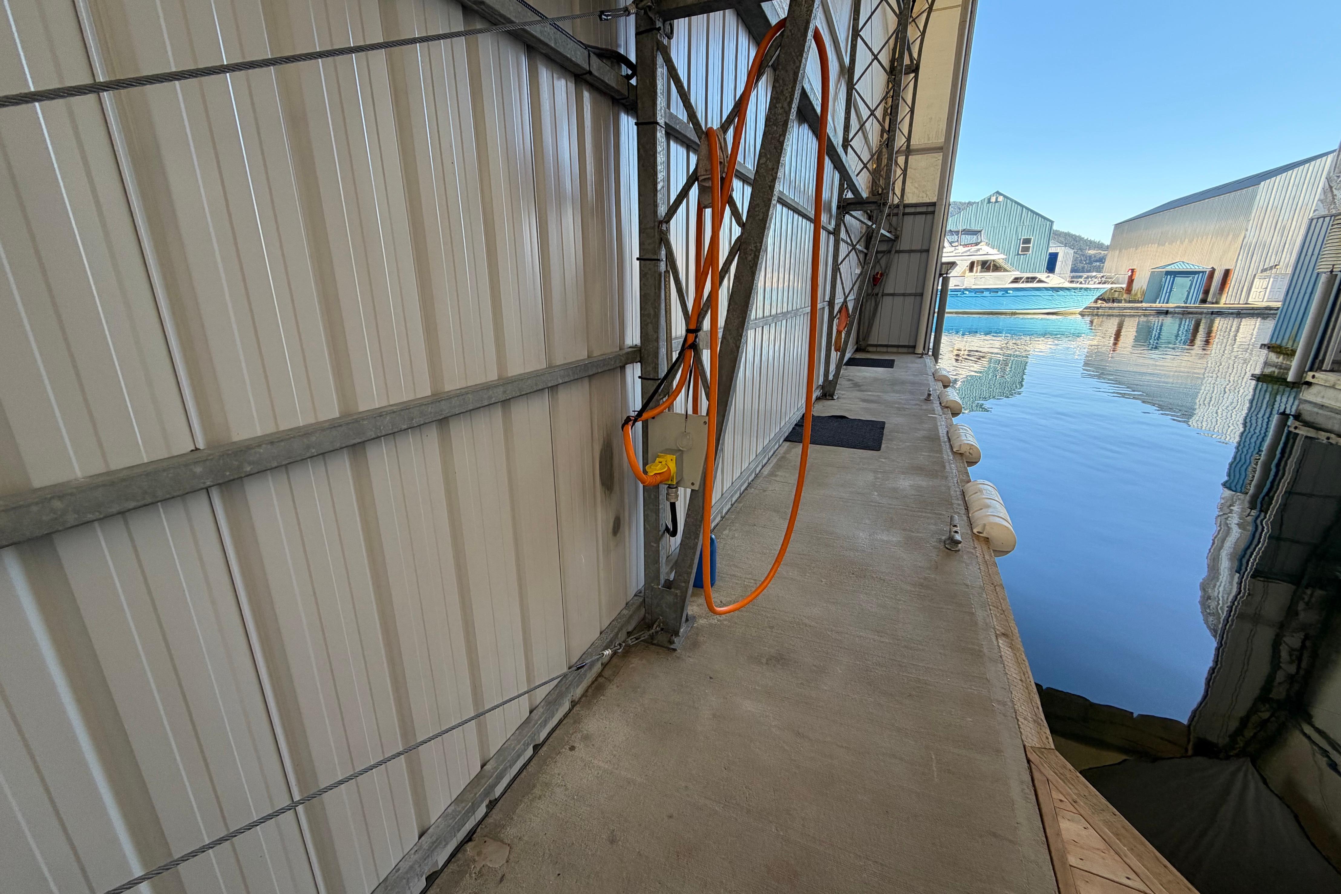 Custom 2006 Boat House interior with dockside view, featuring water and moored boats.