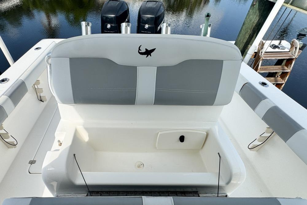 2018 Mako 284 Center Console boat interior with seating and storage, docked by the water.