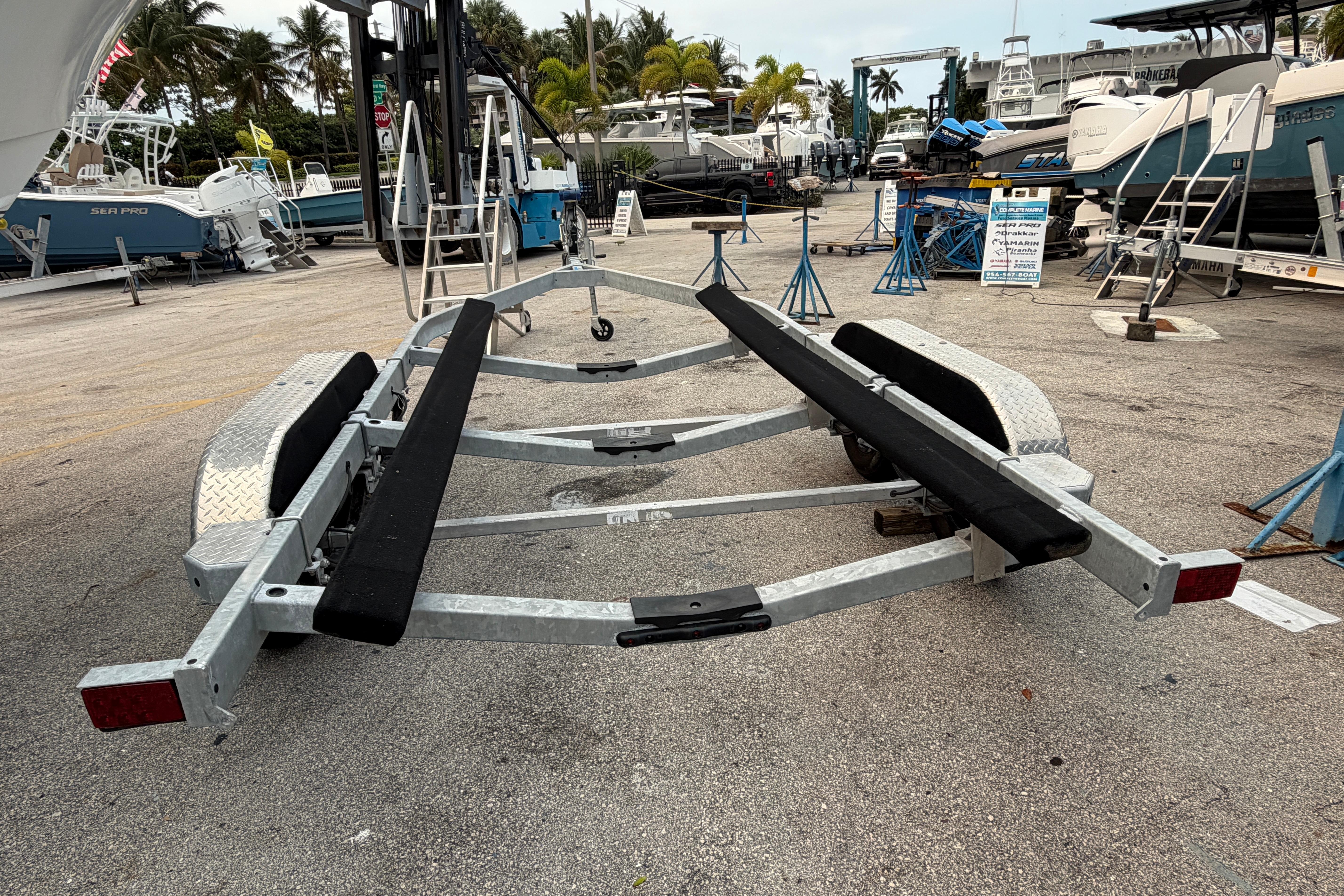 Boat trailer in a marina, surrounded by boats and palm trees, 2024 SRT5000 model.