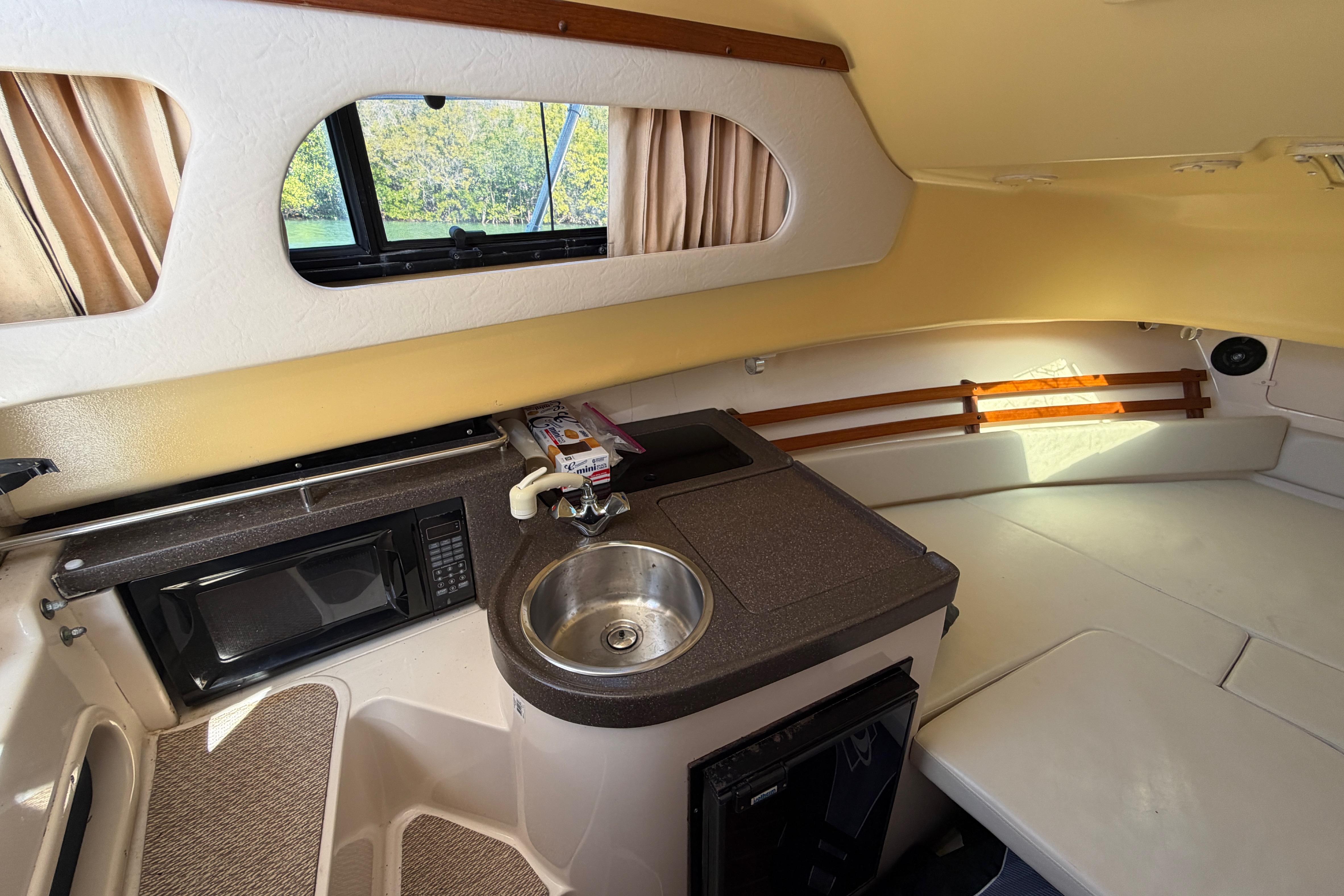 2006 Grady-White Sailfish 282 cabin interior with kitchenette, sink, and window view.