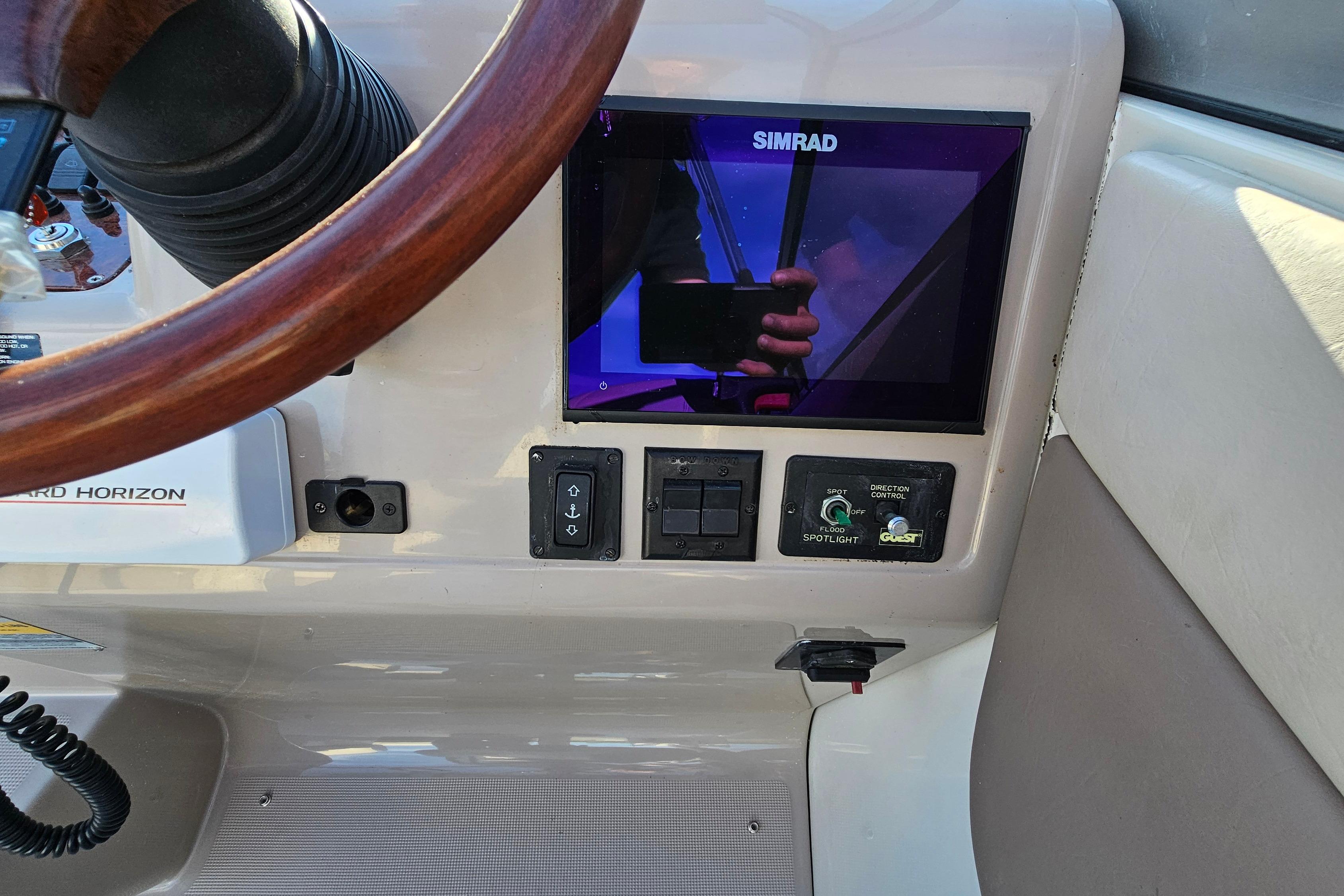 1999 Regal Commodore 258 dashboard with Simrad display and wooden steering wheel.
