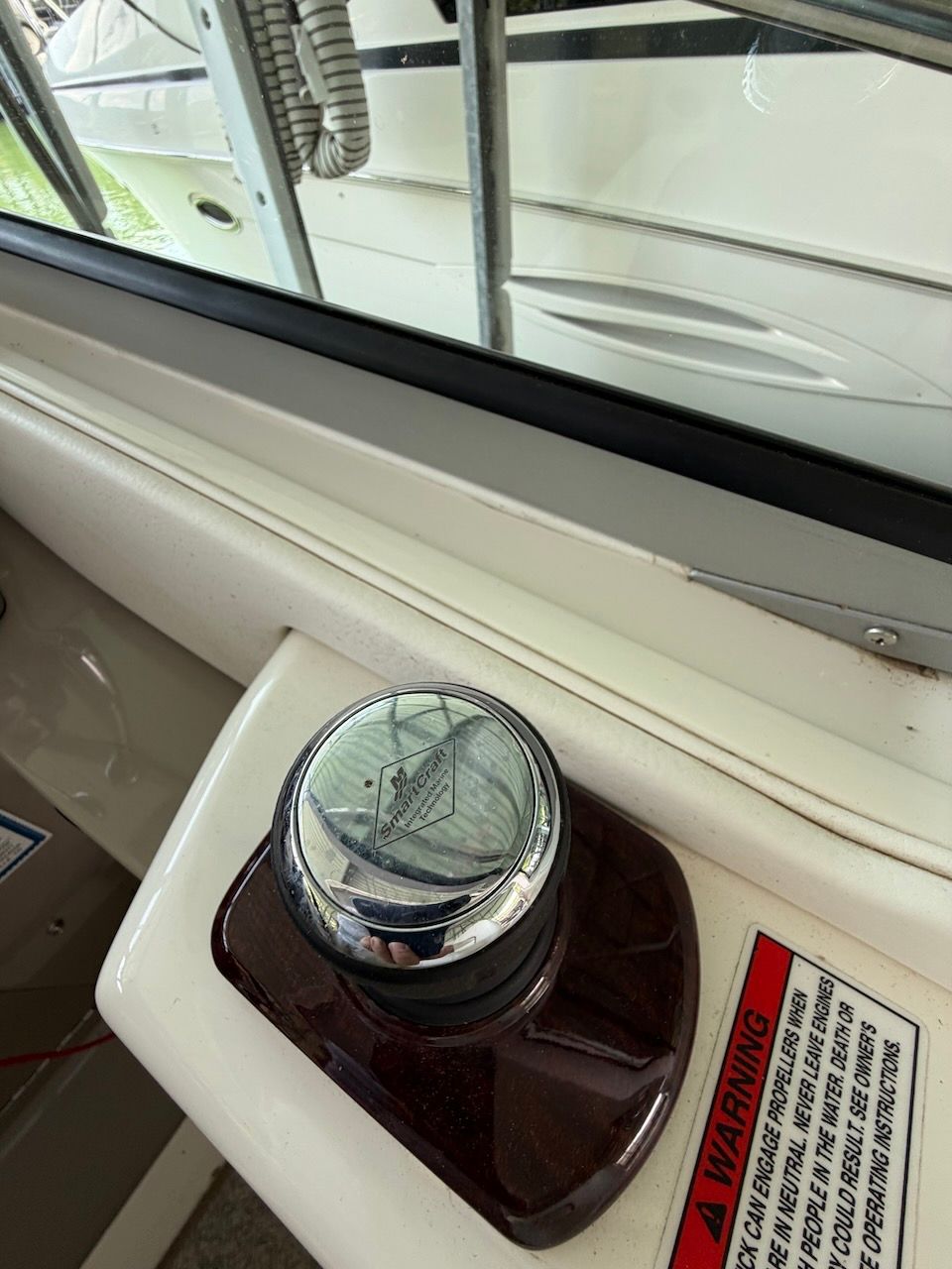 Close-up of a control knob on a boat, with a warning label beside it.