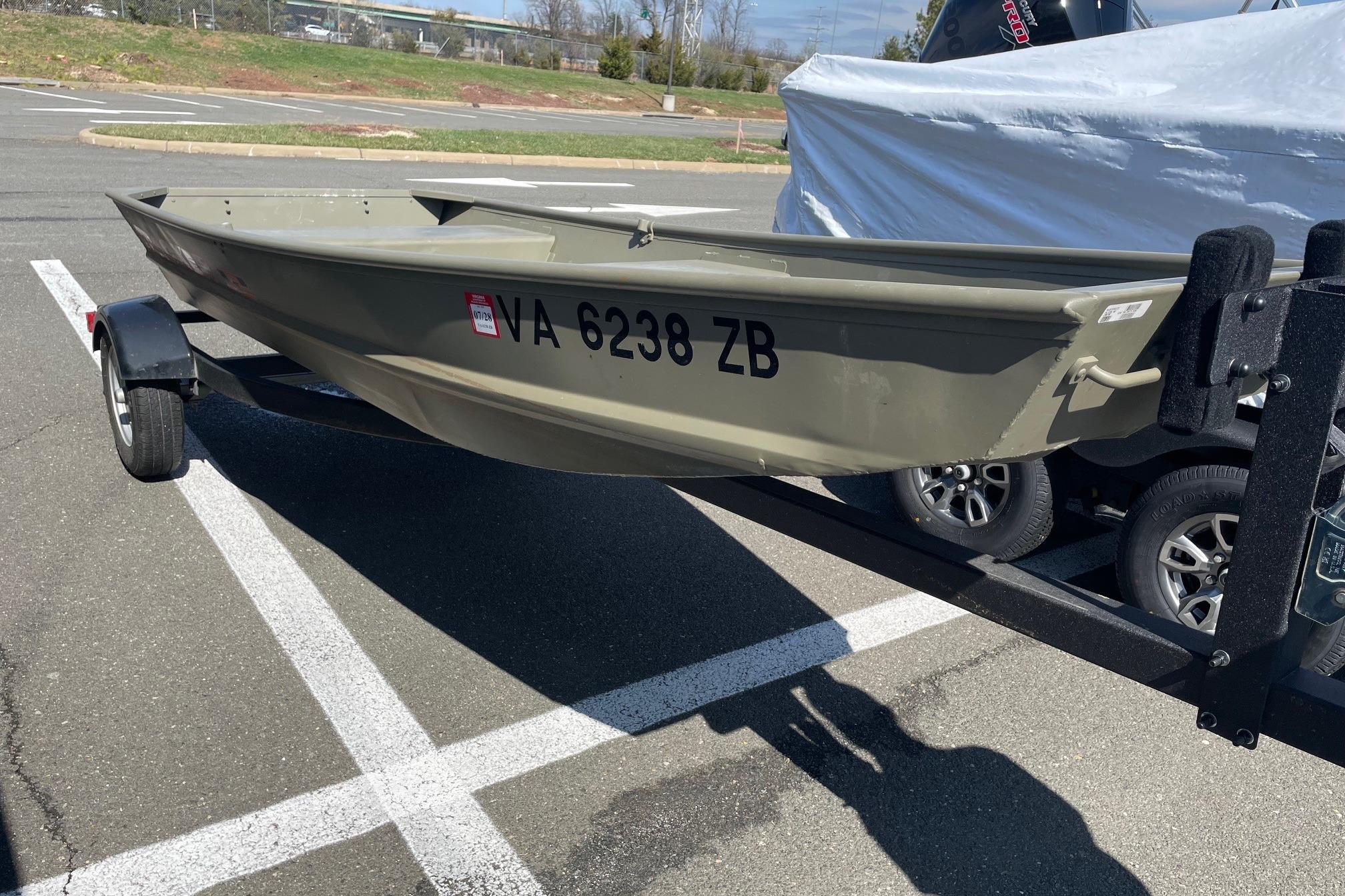 2025 Tracker Grizzly 1236 Jon boat on trailer in parking lot.