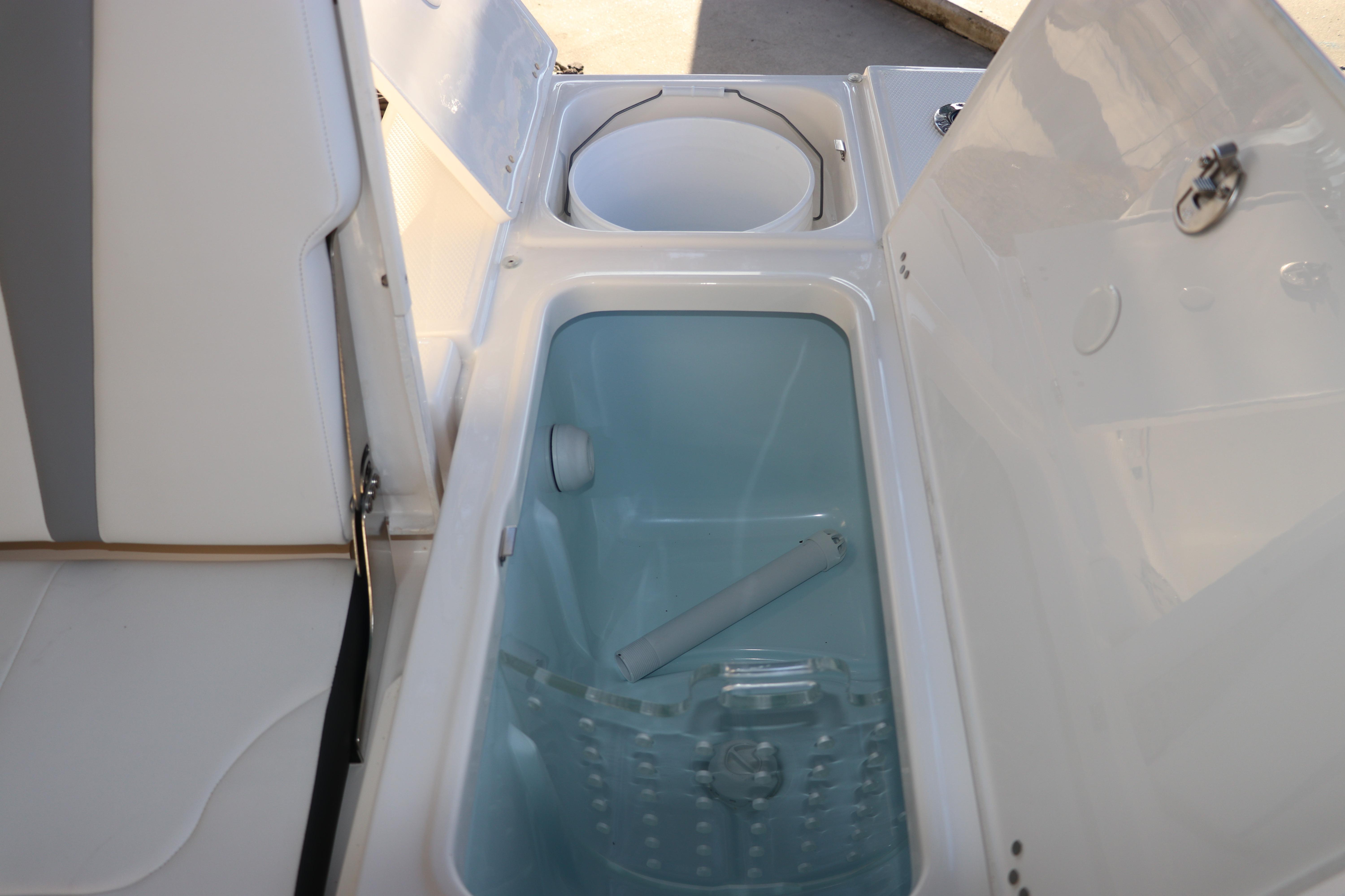 2026 Robalo 246 Cayman boat storage compartments with open lids.
