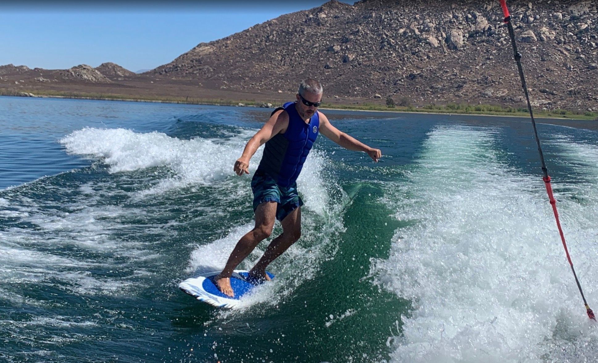 Man surfing behind a 2007 MasterCraft X-2 boat on a lake.