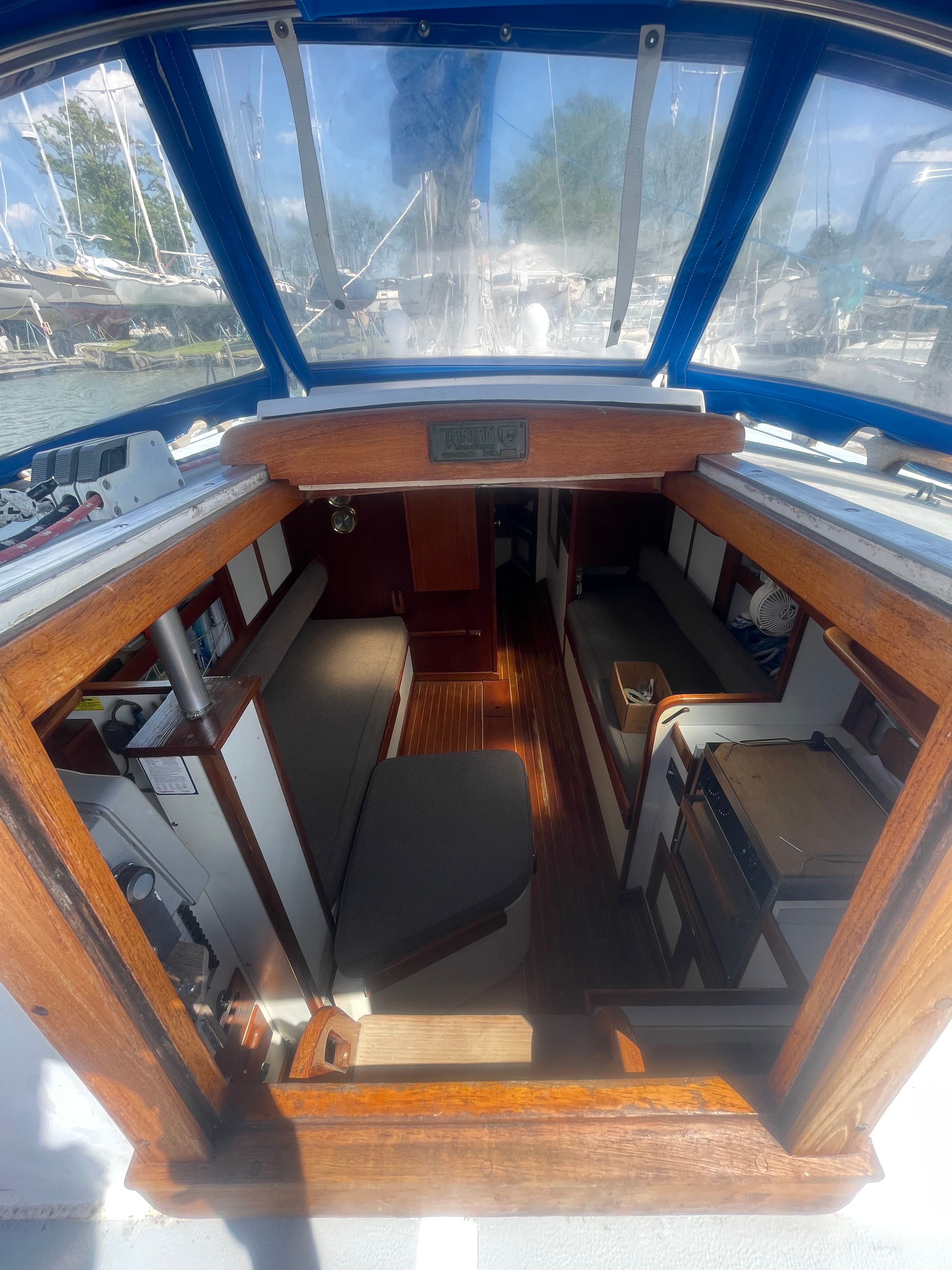Interior of a Tartan 34 Classic yacht with wood finishes and blue upholstery.