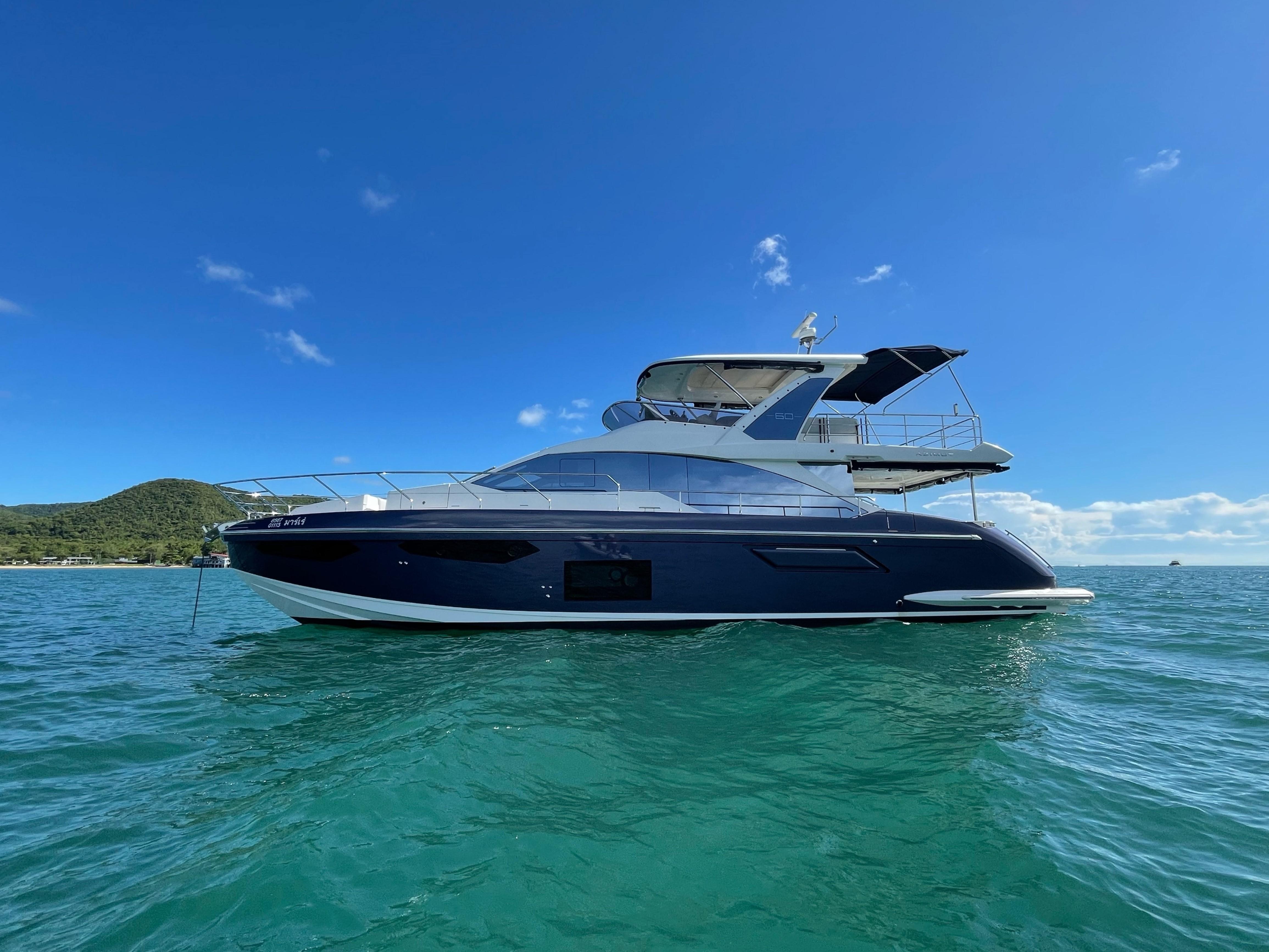 2020 Azimut 60 yacht on clear blue water under a sunny sky.