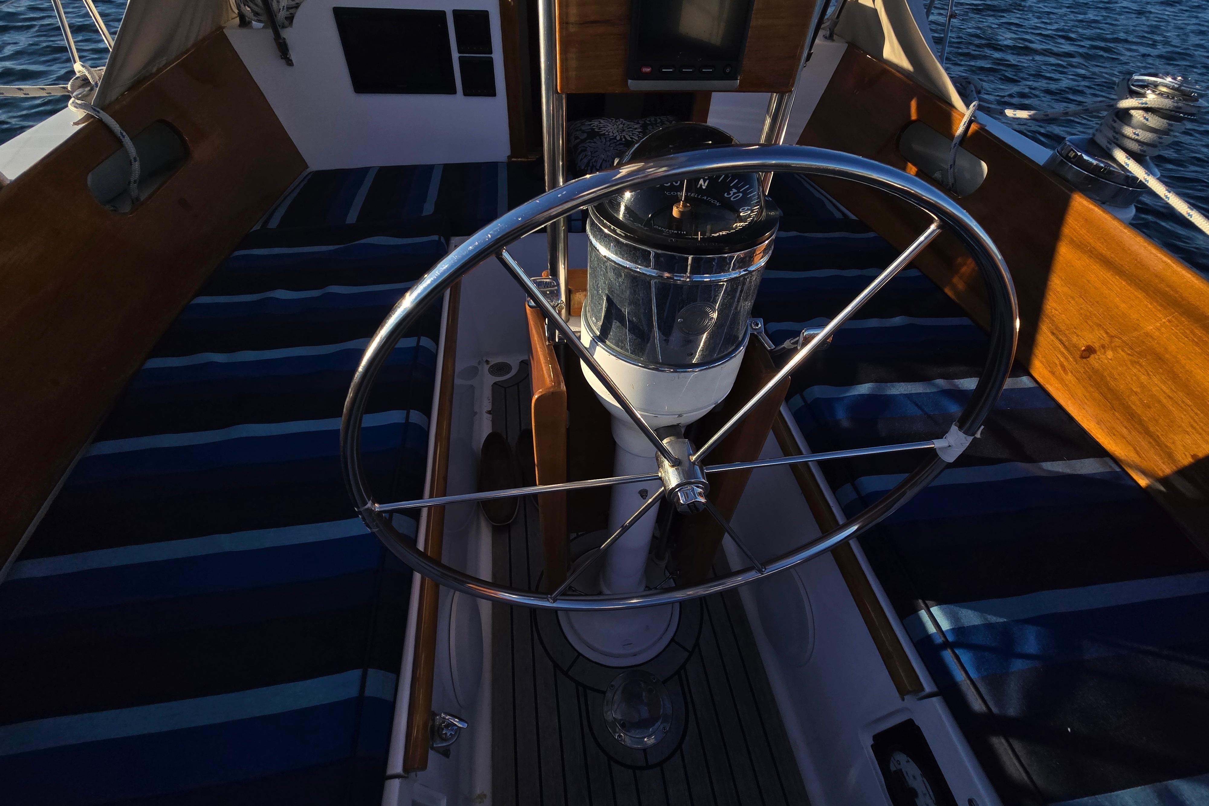 Cockpit of 1970 Hinckley Bermuda 40 sailboat with steering wheel and compass.