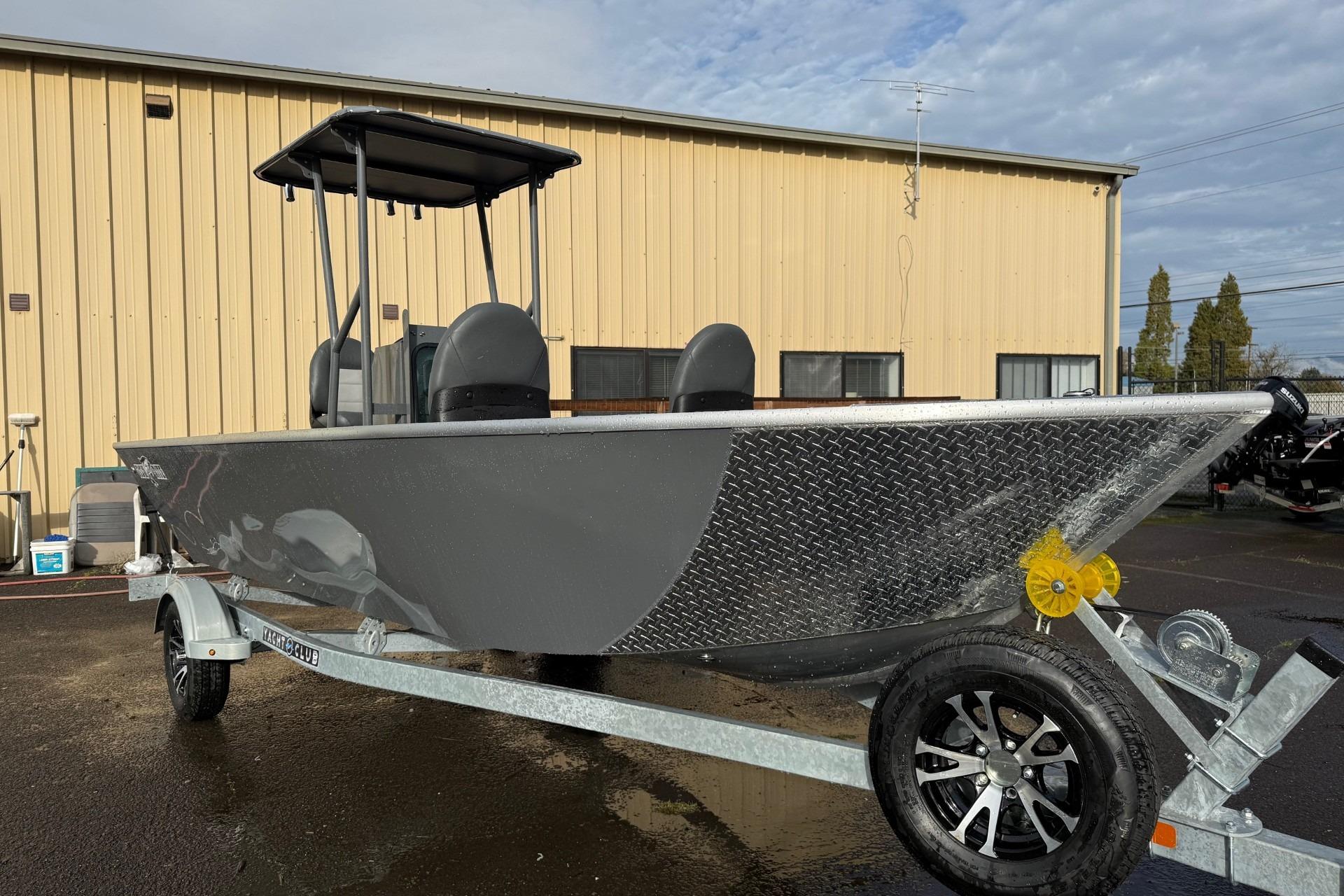 2026 Fish Rite Angler 18 boat on trailer, parked outside a beige building.