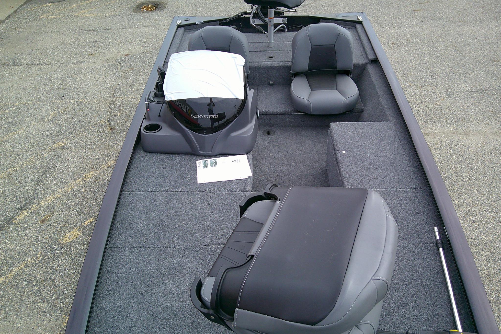 2025 Tracker Pro 170 boat interior with seating and motor, parked on pavement.