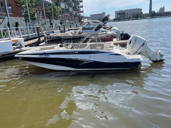 2020 Crownline E 205 XS boat docked on a sunny waterfront.