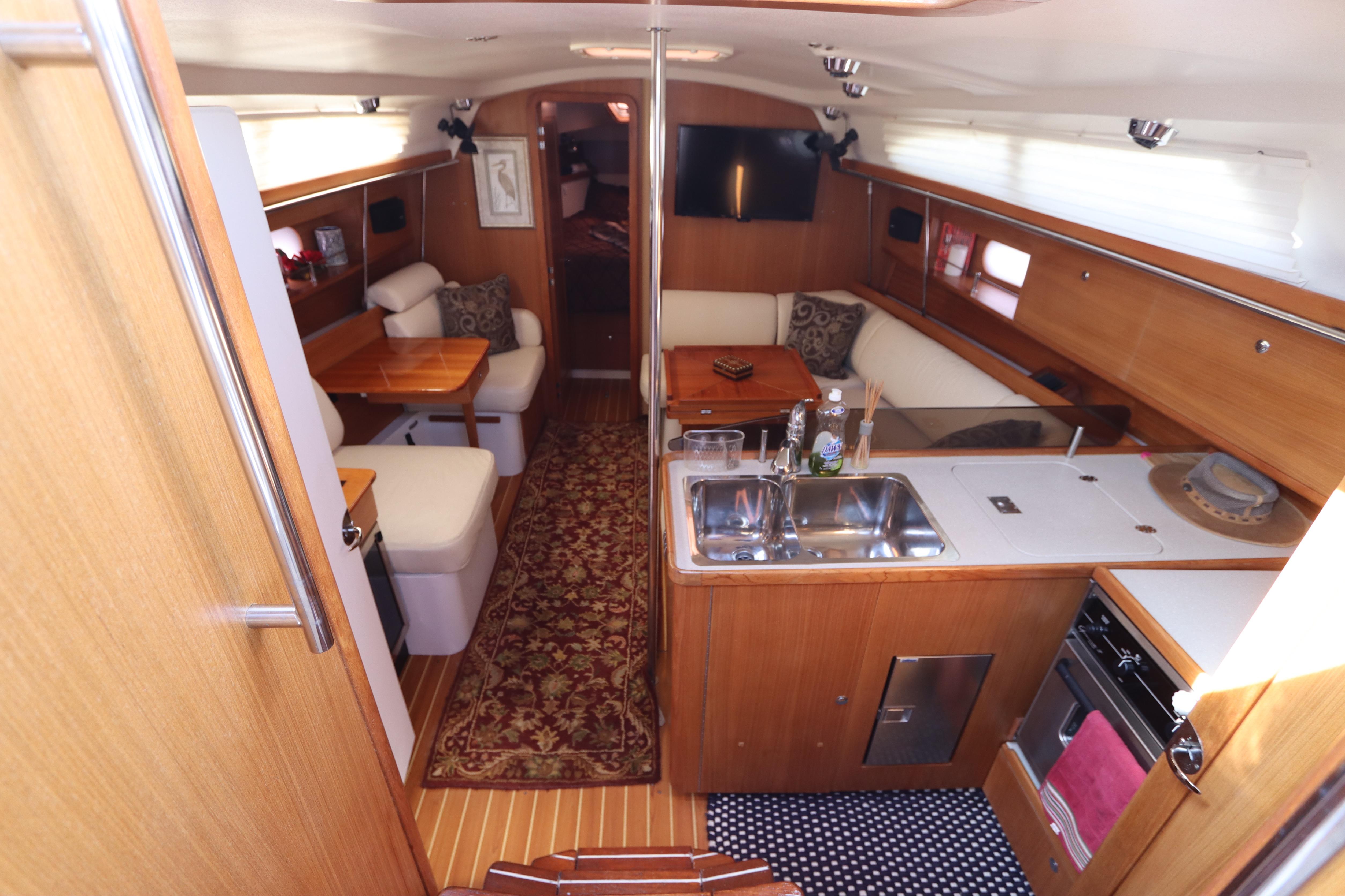 Interior of 2011 Catalina 355 sailboat with cozy seating and modern kitchen amenities.