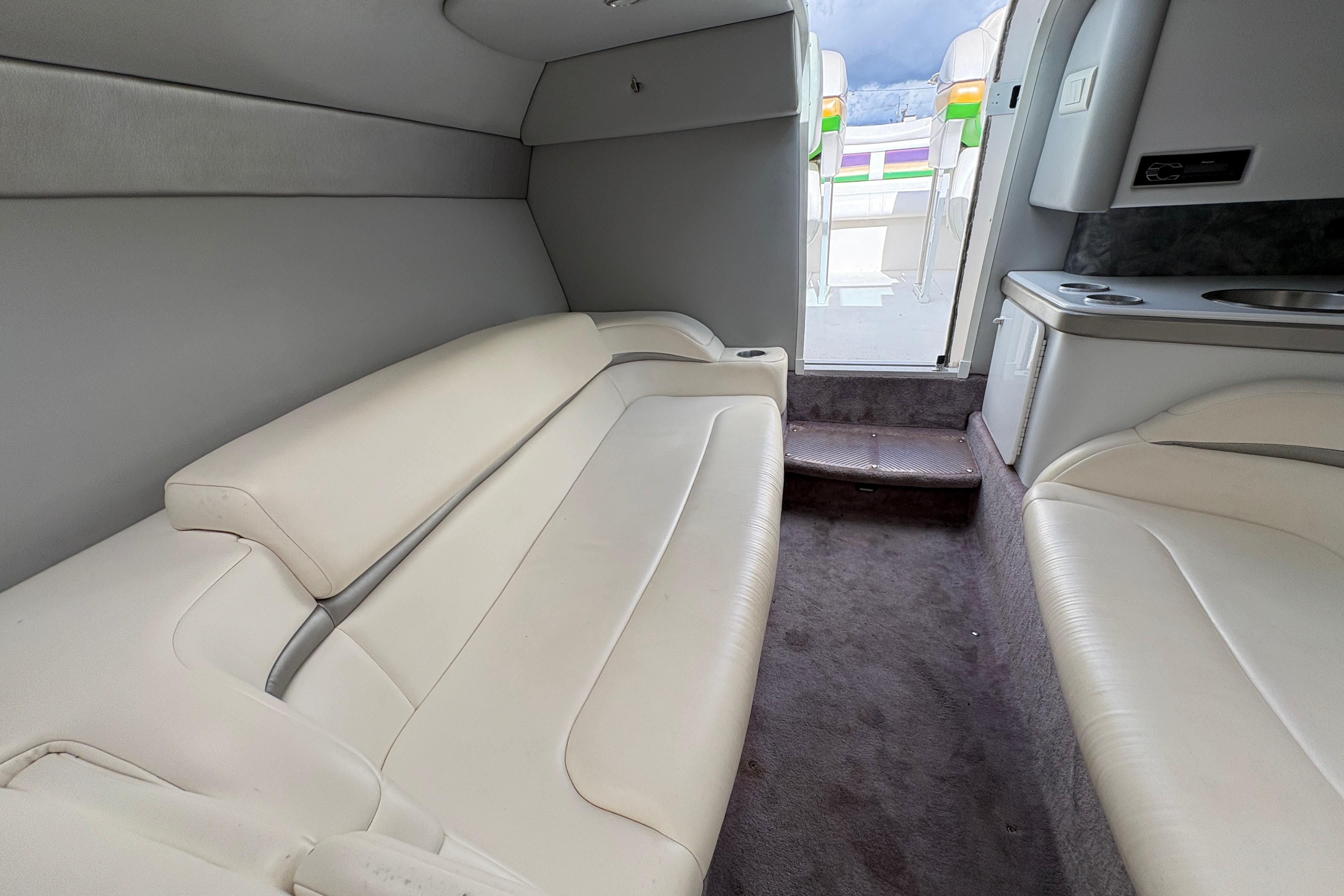 Interior of a 2002 Formula 292 FASTech boat with white leather seating and compact kitchenette.