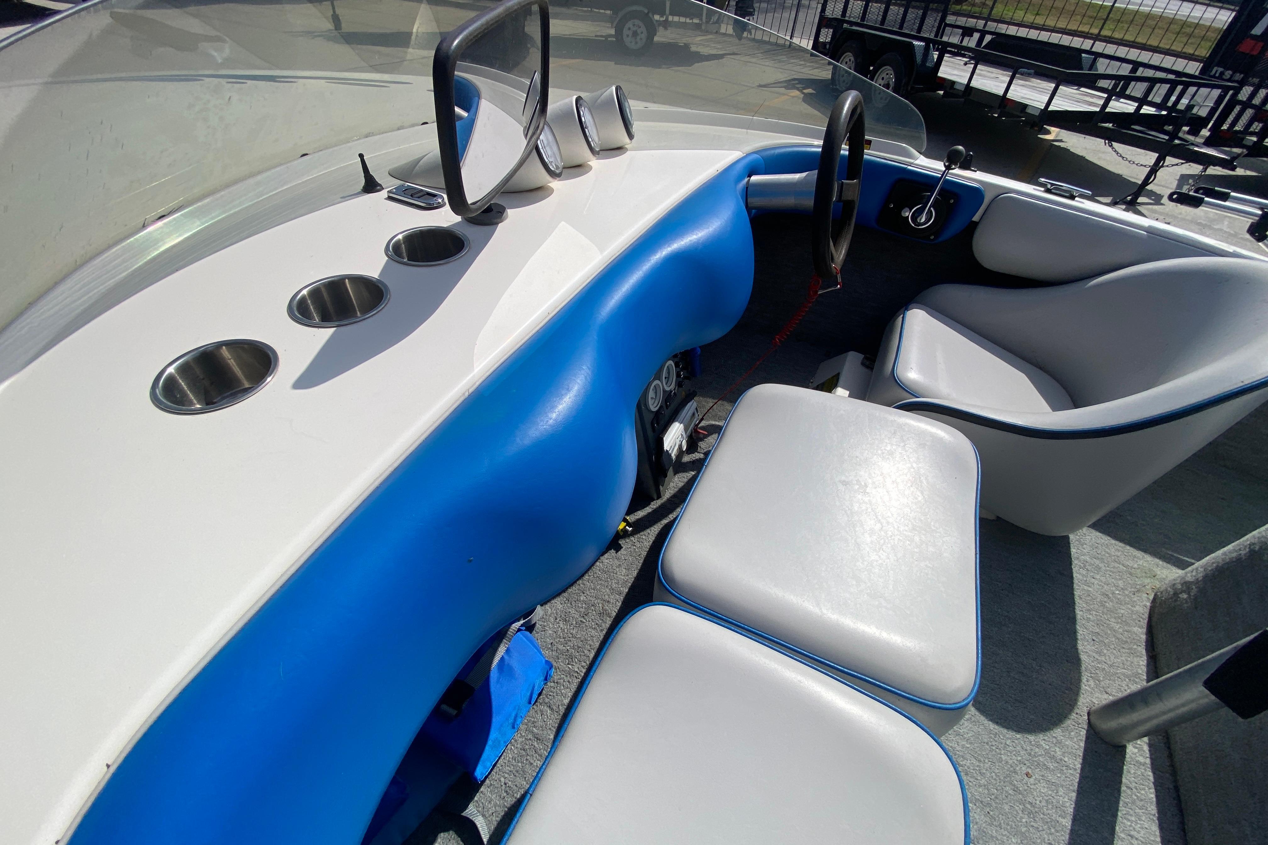 1997 Malibu Tantrum boat interior with blue and white seating and cup holders.