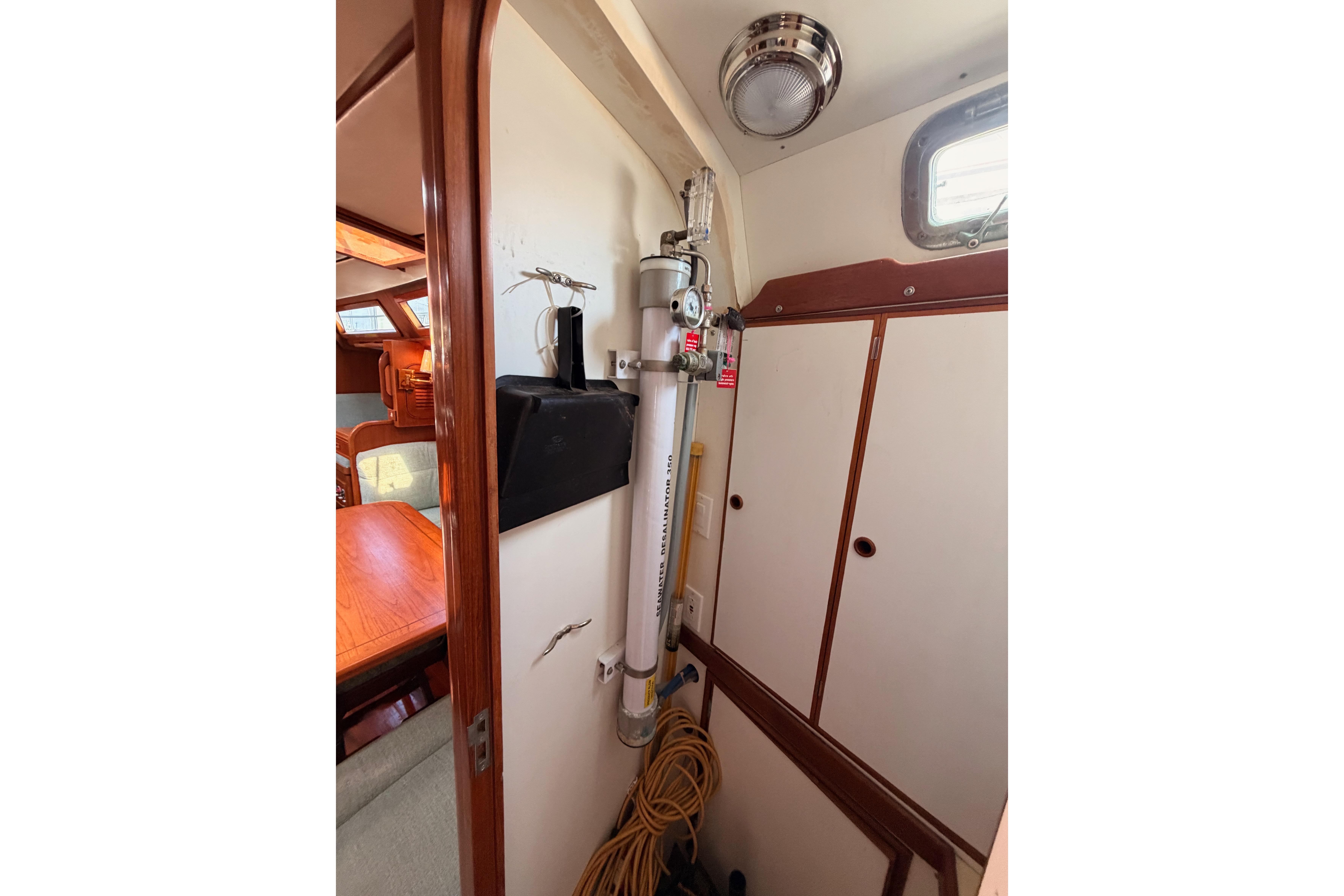 Interior of a 1991 Hylas 51 yacht, featuring a compact storage area and wooden cabinetry.