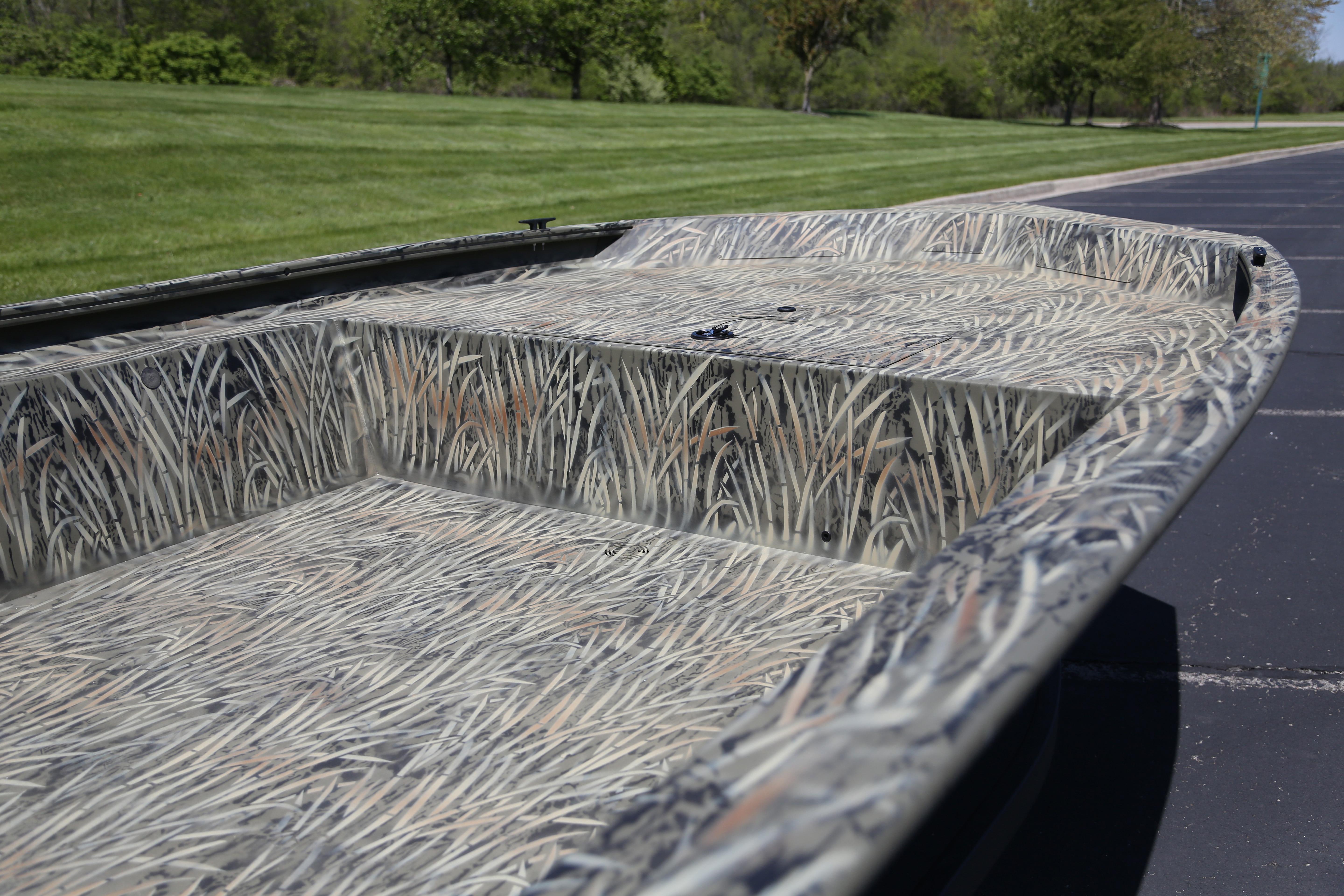 2026 Tracker Grizzly 1754 Utility boat with camouflage pattern on a sunny day.