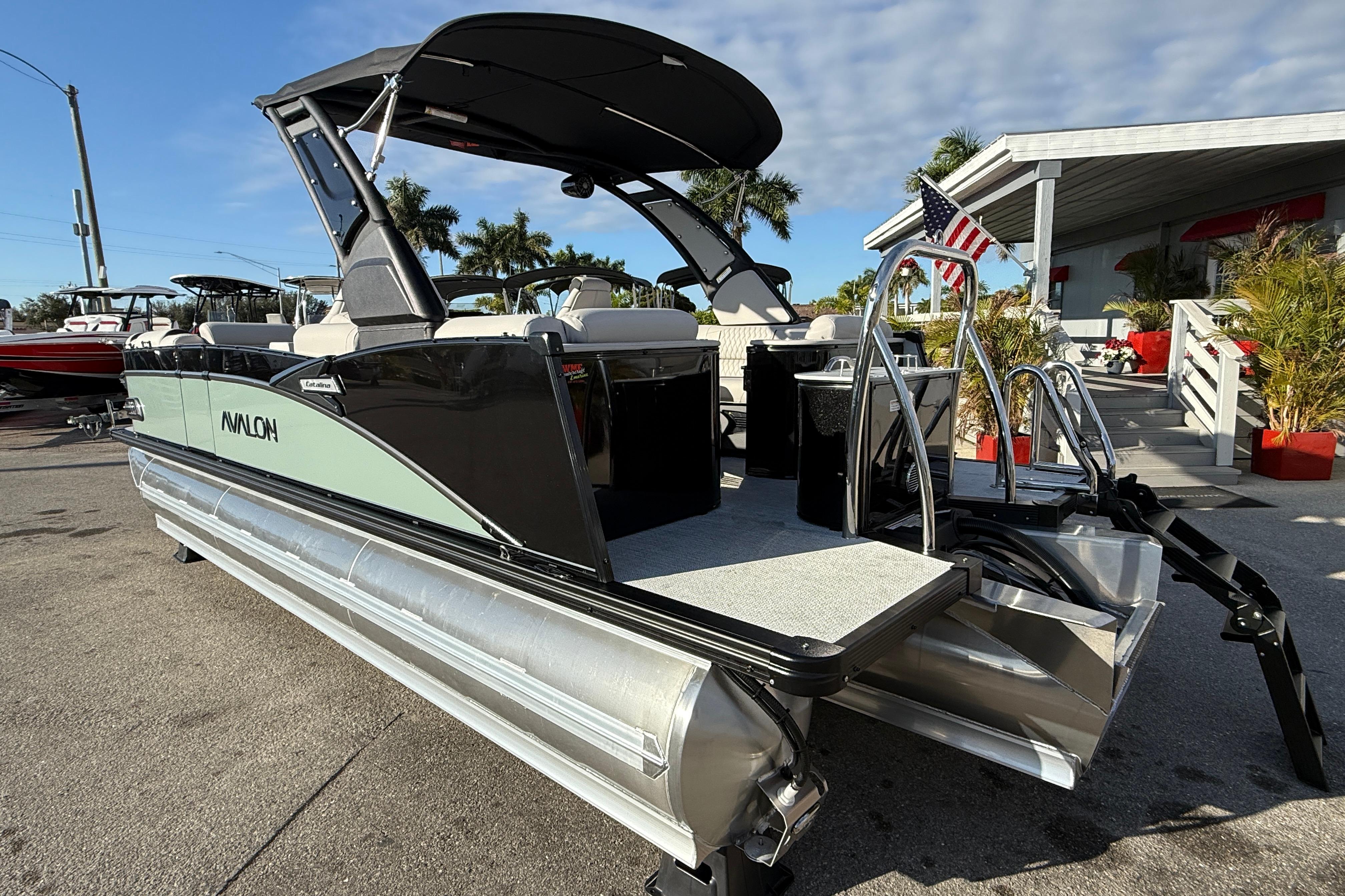2026 Avalon 2385 Catalina Quad Lounger Tri Toon, high-performance pontoon boat, docked outdoors.