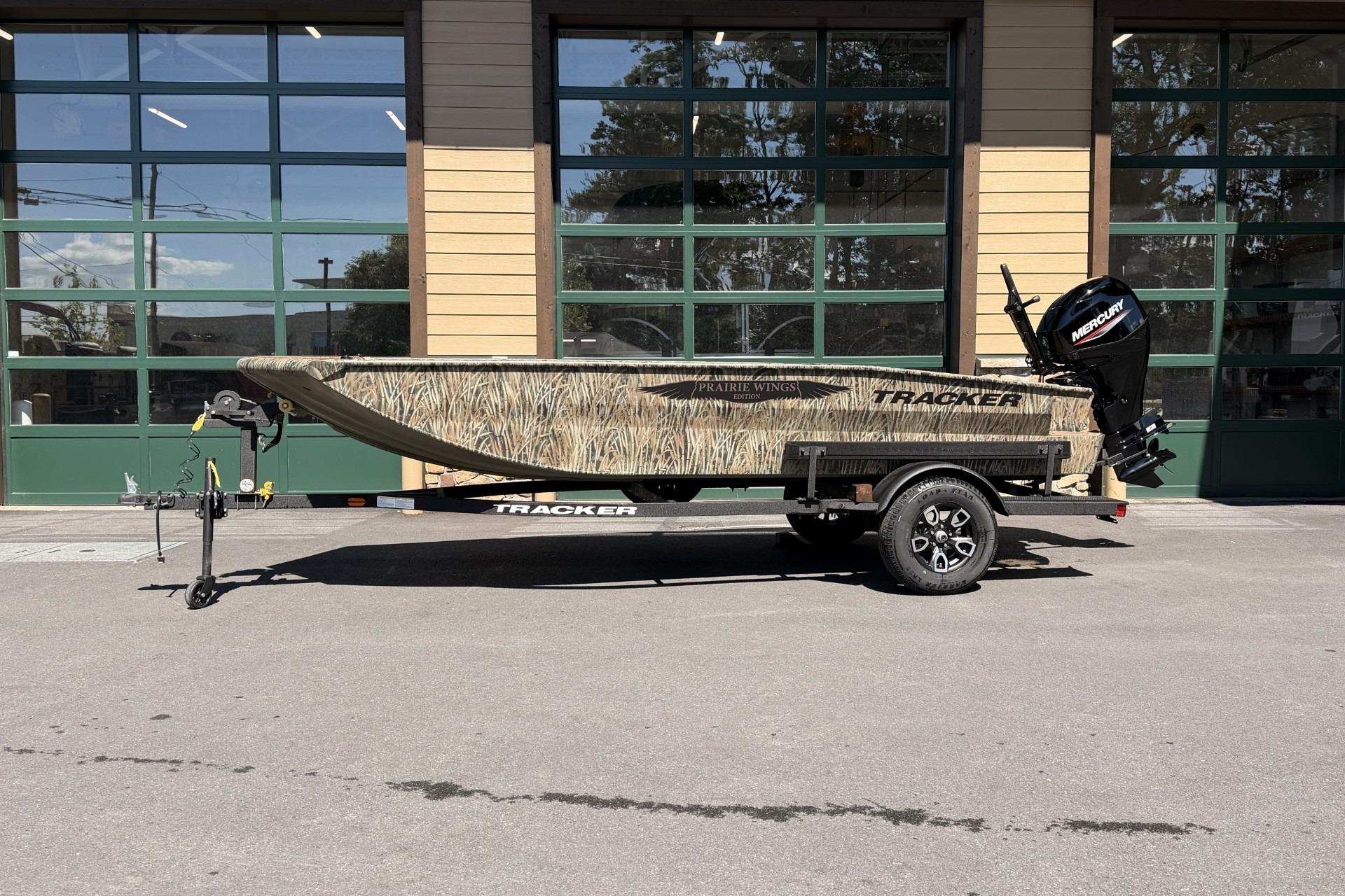 2026 Tracker Grizzly 1650 T Prairie Wings Edition boat on trailer, parked outdoors.
