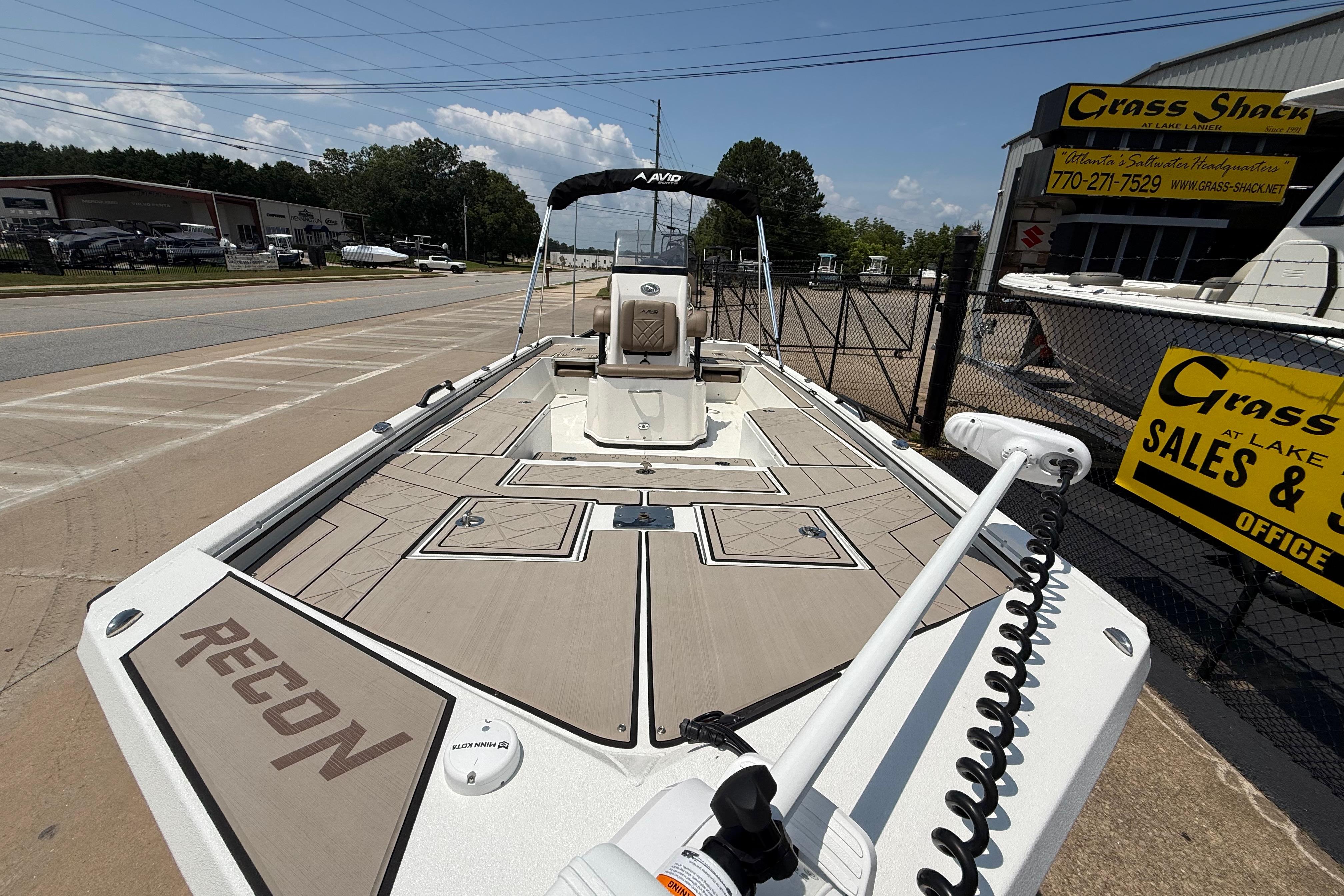 Avid 22 Recon 2025 boat displayed at dealership, showcasing sleek design and spacious deck.