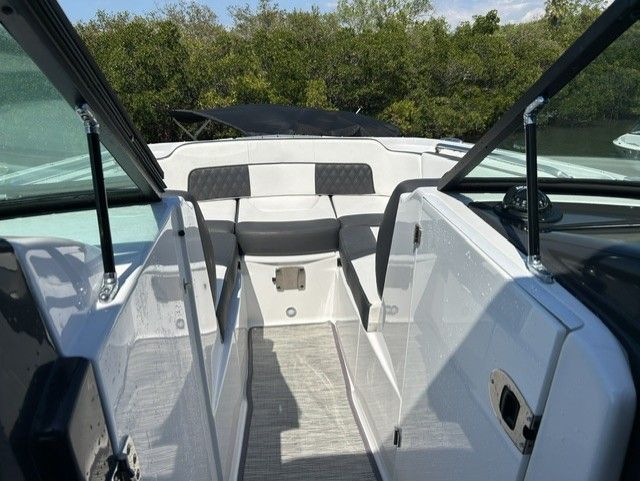 The boat features an open cabin with white seating and glass walls.