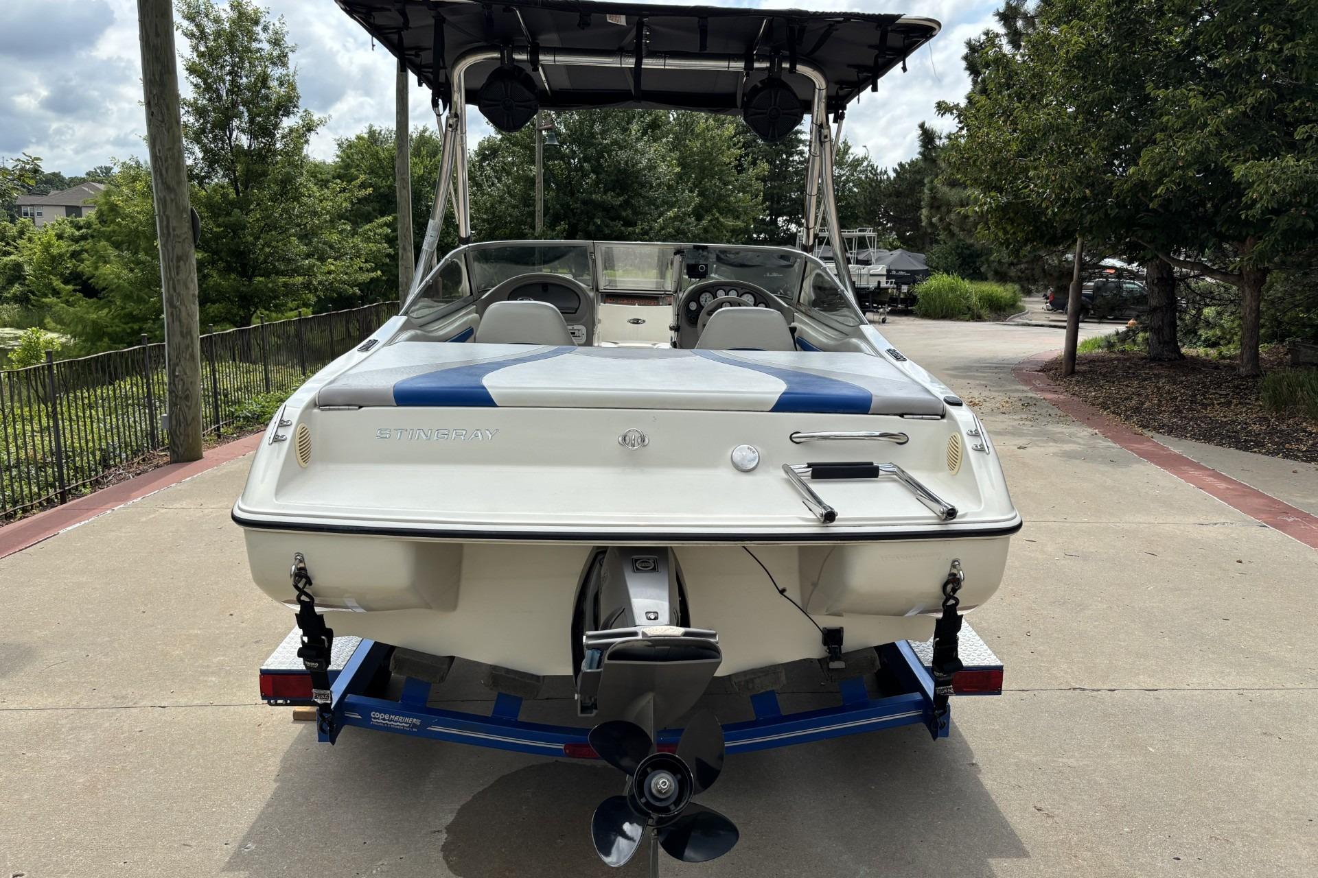2007 Stingray 180 RX boat on trailer, rear view, parked outdoors.