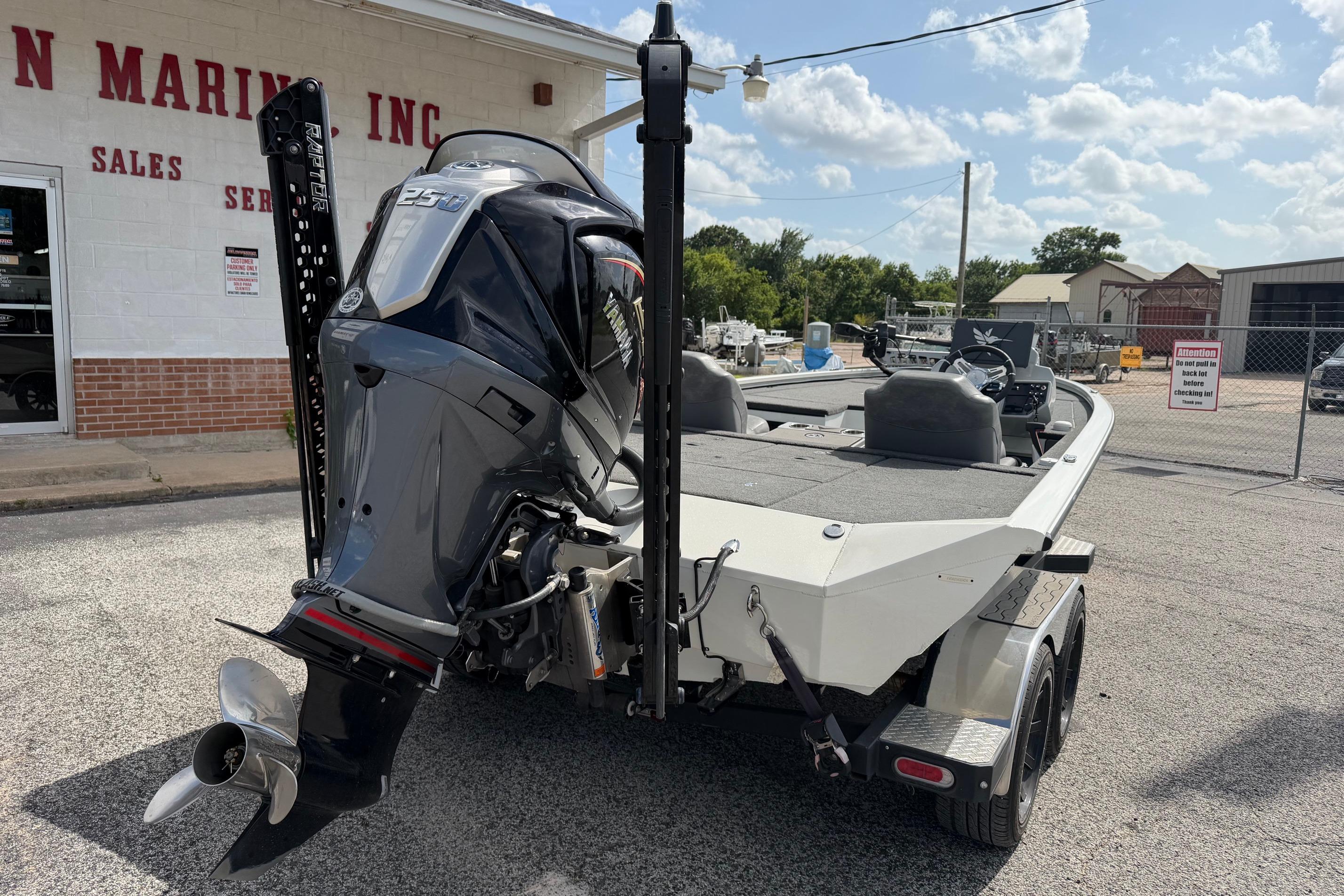 2024 Avid 21 XB Elite boat with powerful outboard motor, parked outside dealership.