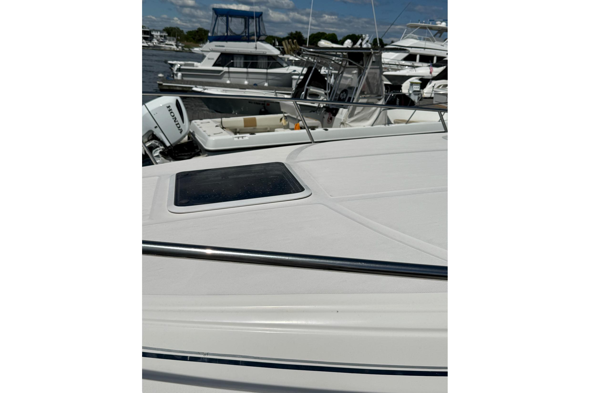 2006 Sea Ray 300 Sundancer boat docked, featuring sleek deck design and nearby vessels.