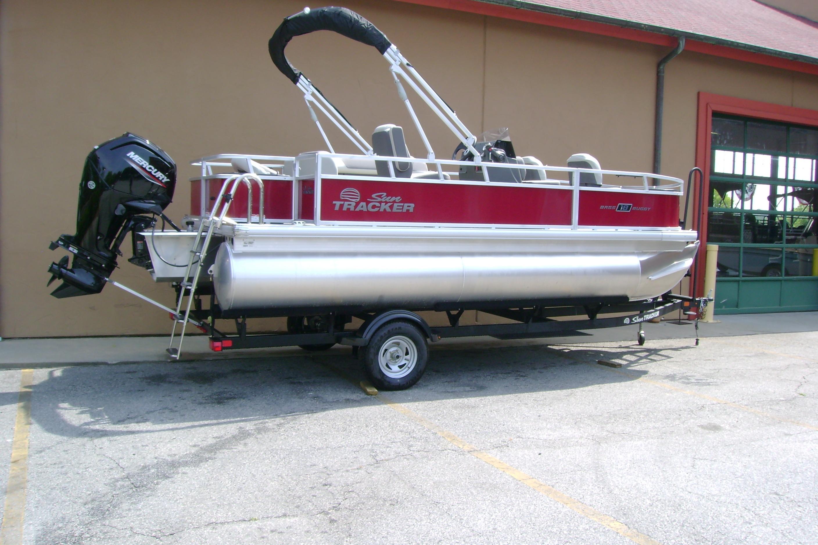 2026 Sun Tracker Bass Buggy 18 DLX pontoon boat on trailer, parked outdoors.