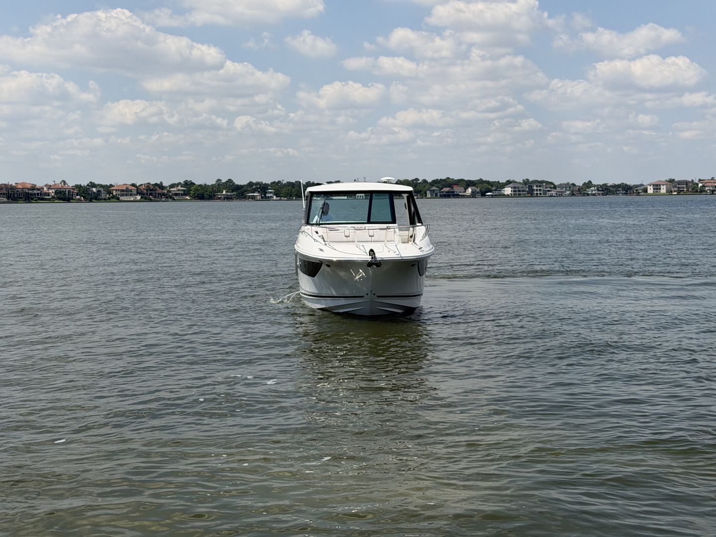 2026 Sea Ray Sundancer 320 Outboard on calm water under cloudy sky.