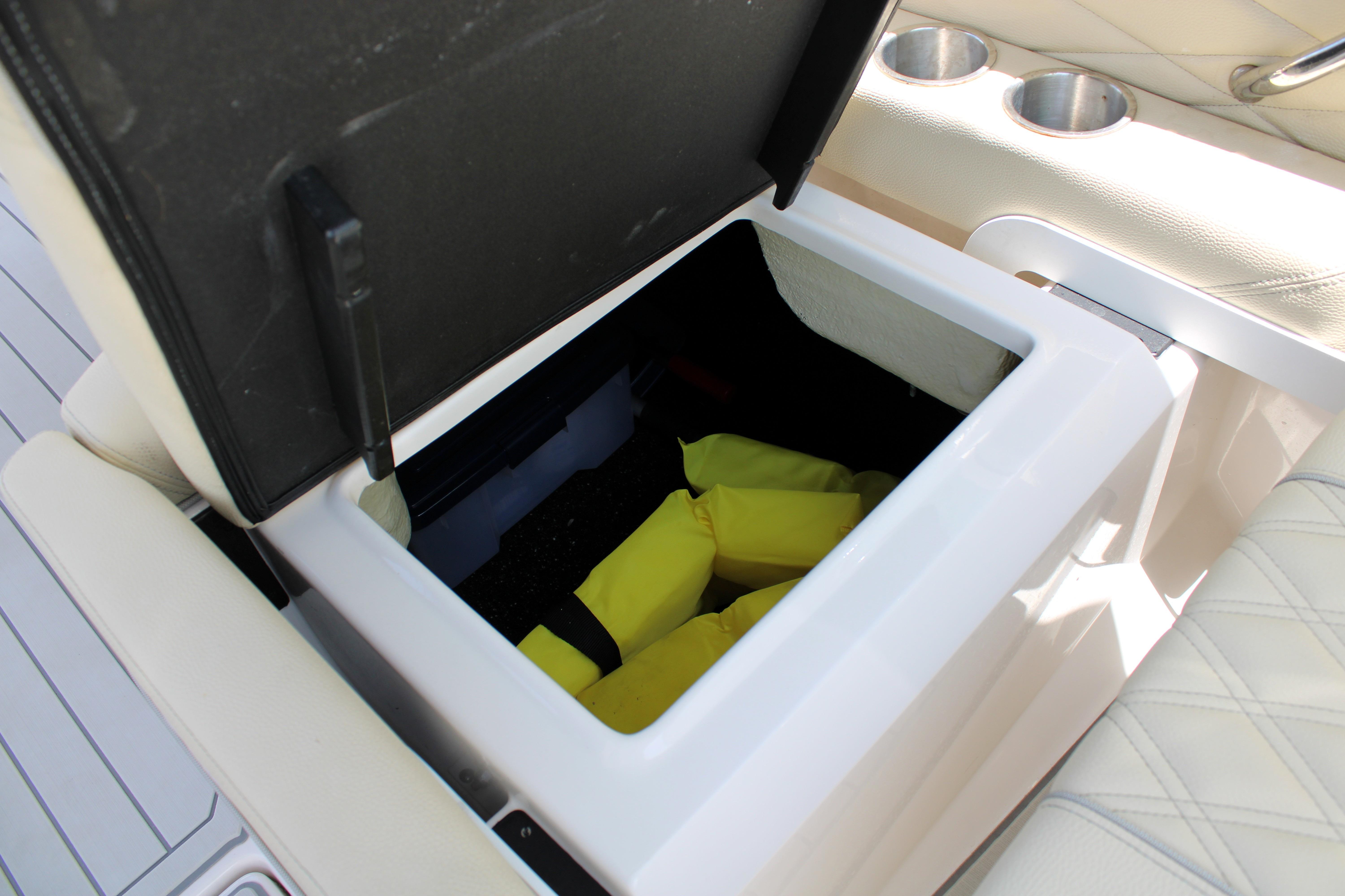 Storage compartment on 2021 Regal 26 OBX boat with yellow life jackets inside.