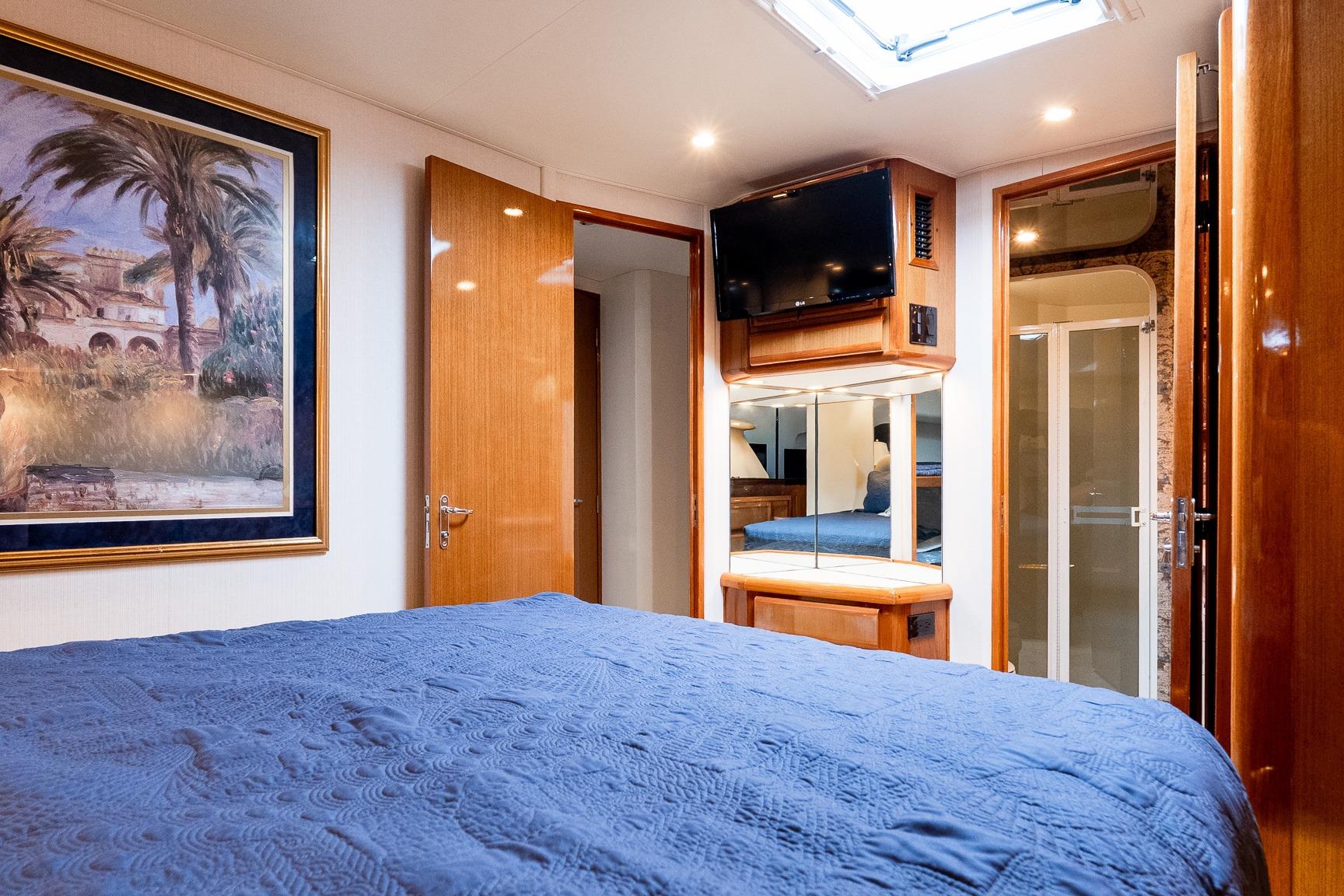 Luxurious bedroom interior of 2000 Viking 50' Convertible yacht with elegant decor and modern amenities.