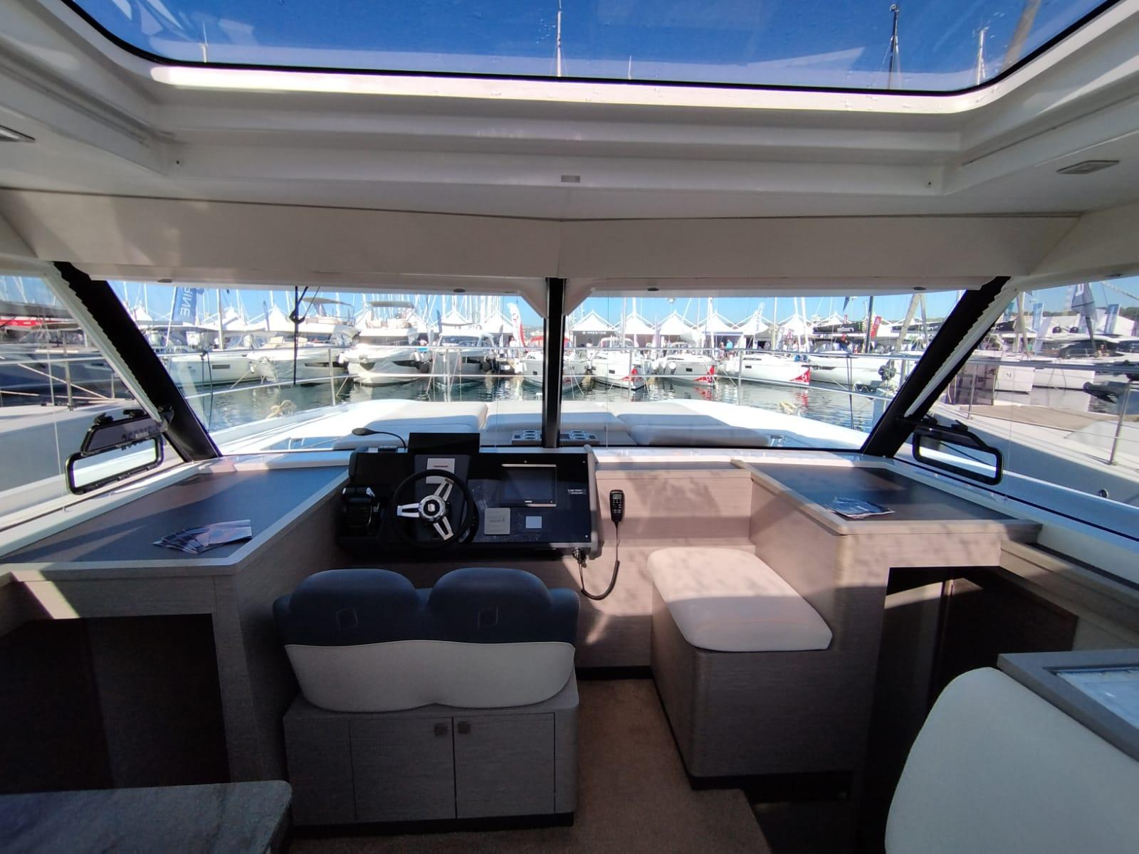 Interior view of 2022 Fountaine Pajot MY4.S yacht cockpit with marina background.