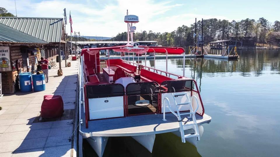 2024 Aloha Pontoon 50' Water Taxi docked at a scenic lakeside marina.
