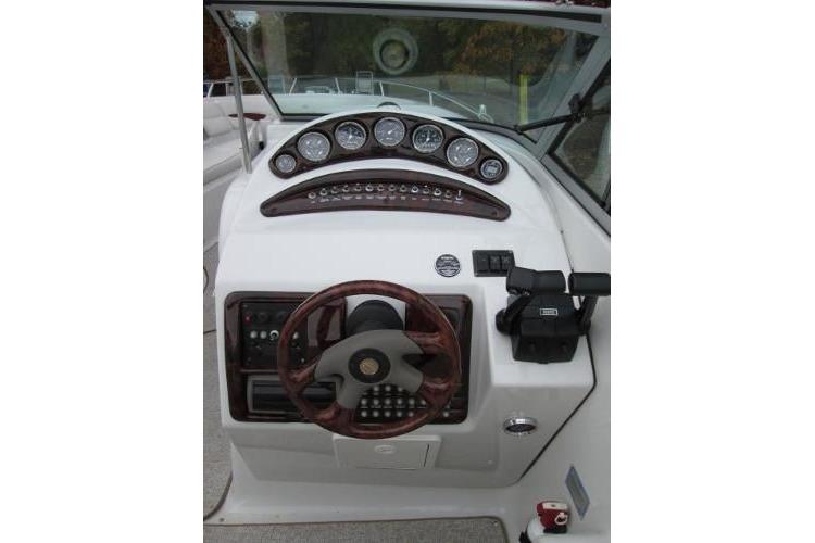 Dashboard of a 2004 Crownline 288 BR boat with gauges and steering wheel.