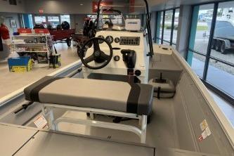 2026 Crestliner 1860 Retriever CC boat interior with steering console and seating in showroom.