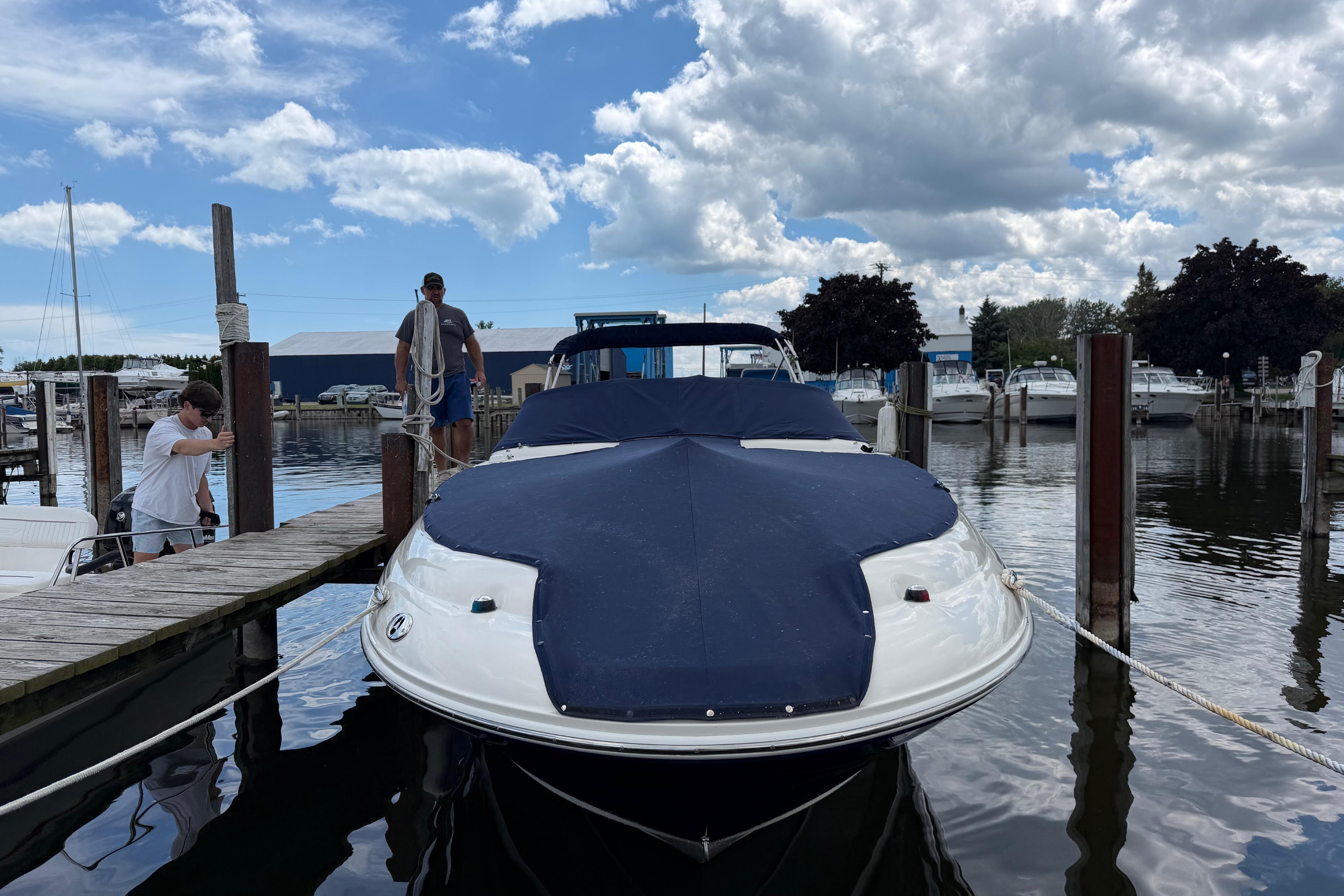2004 Sea Ray 240 Sundeck docked at marina under cloudy sky.