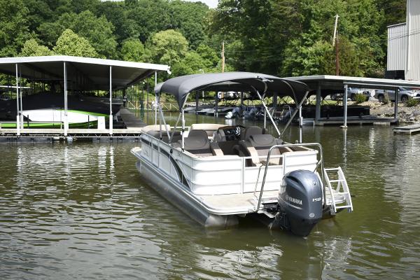 2023 Bennington 22 SXCW pontoon boat docked on a calm lake.