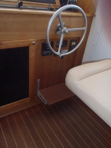 Interior helm of 2025 Great Harbour N40 boat with wooden finish and steering wheel.