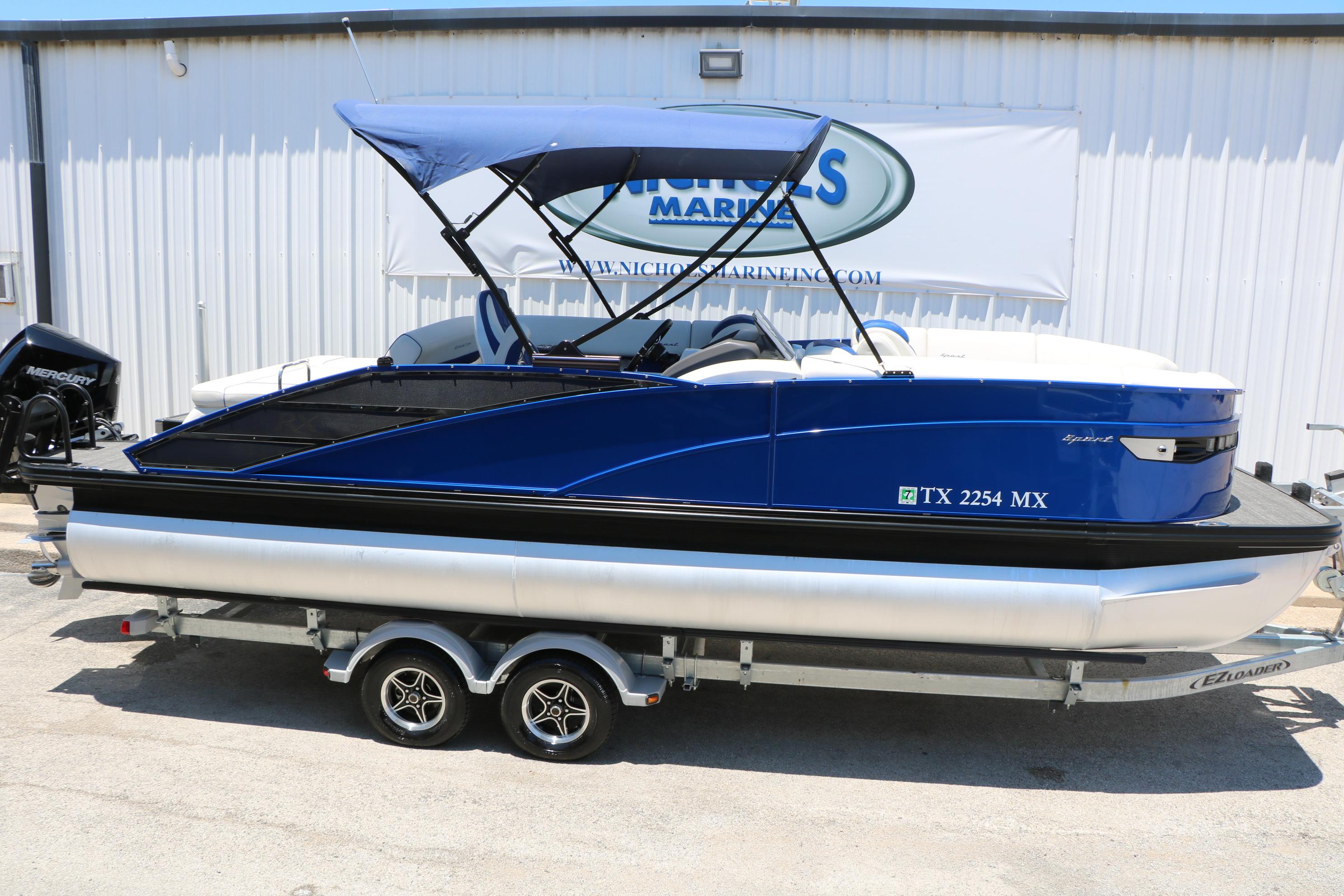 2024 Bennington 23 RX Swingback pontoon boat on trailer, blue exterior, parked outdoors.