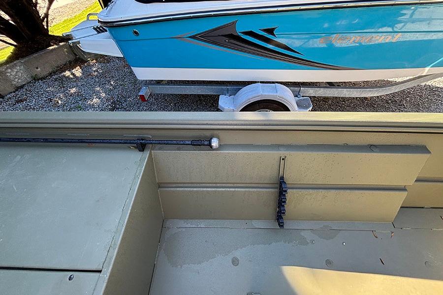 2022 Lowe Roughneck 1660 boat interior with blue boat on trailer in background.