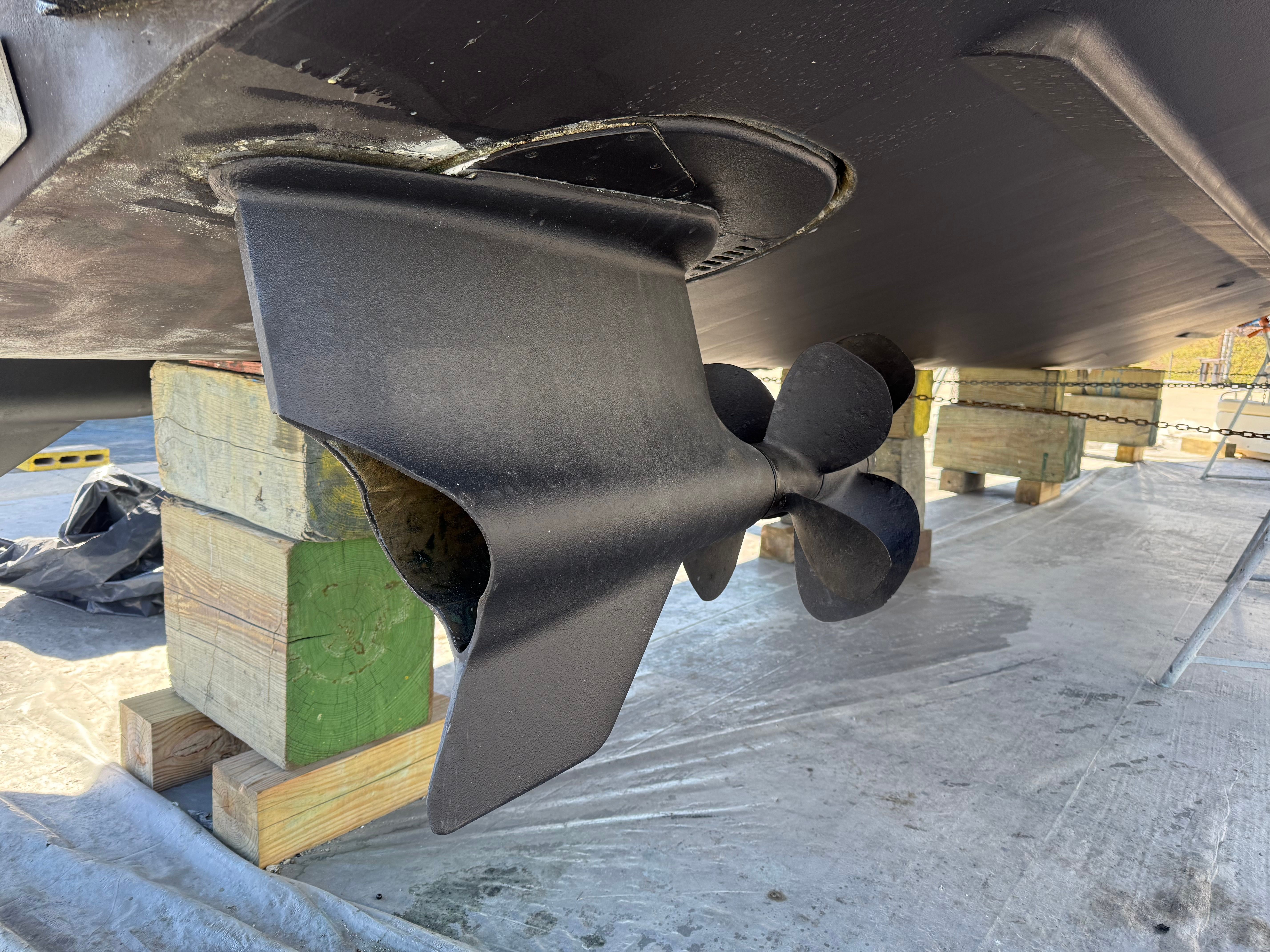 Propeller and rudder of a 2007 Chris-Craft Roamer 40 on wooden blocks.
