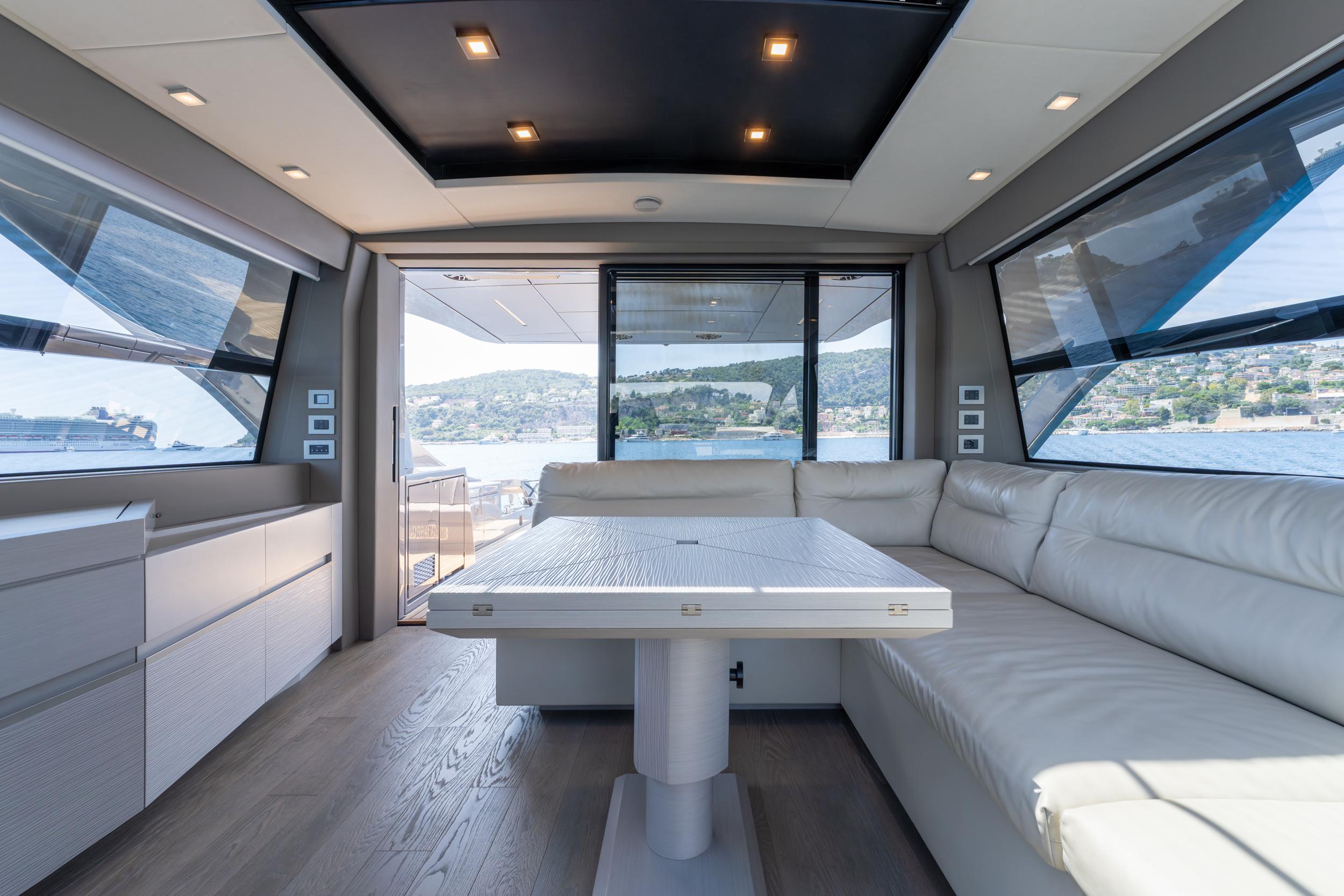 Luxurious interior of 2024 Pershing 7X yacht with panoramic windows and modern seating.
