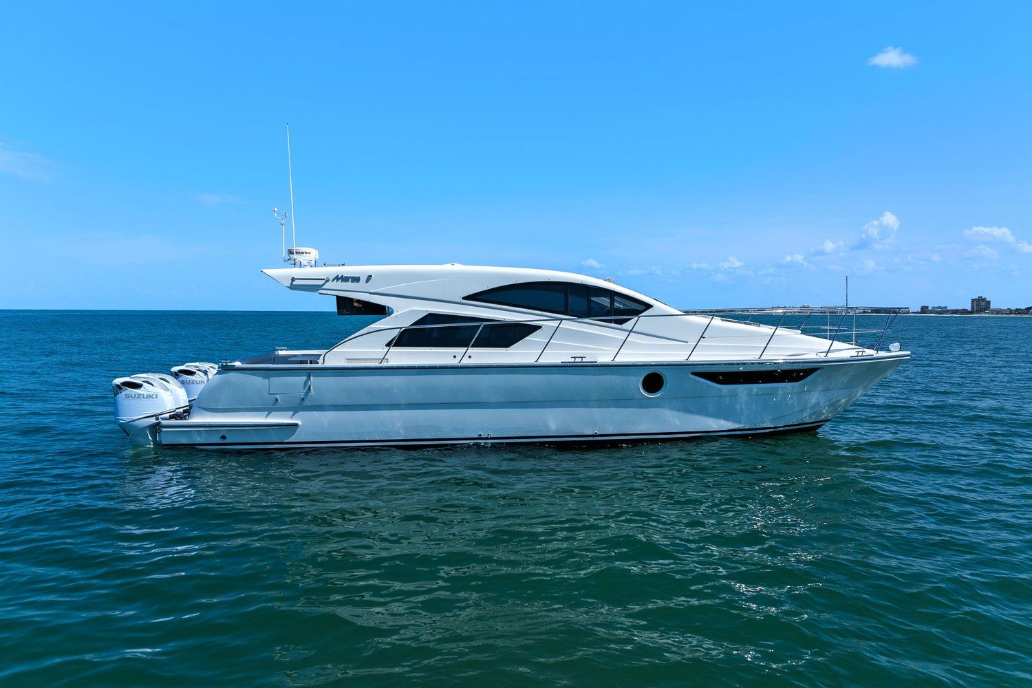 A sleek, modern catamaran with a streamlined design, on calm water under a blue sky.