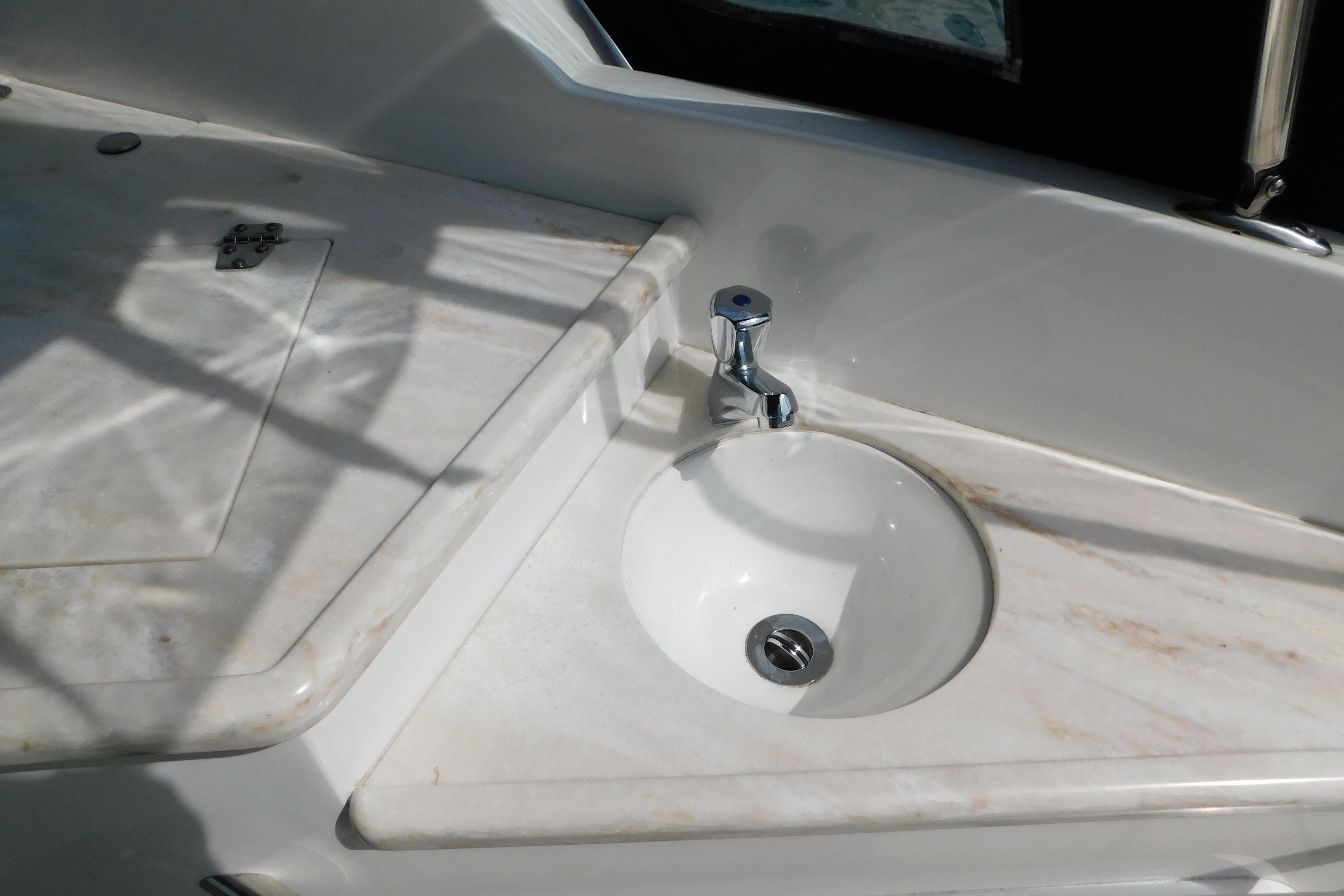 2017 Rinker EX 320 boat sink with marble countertop and chrome faucet.