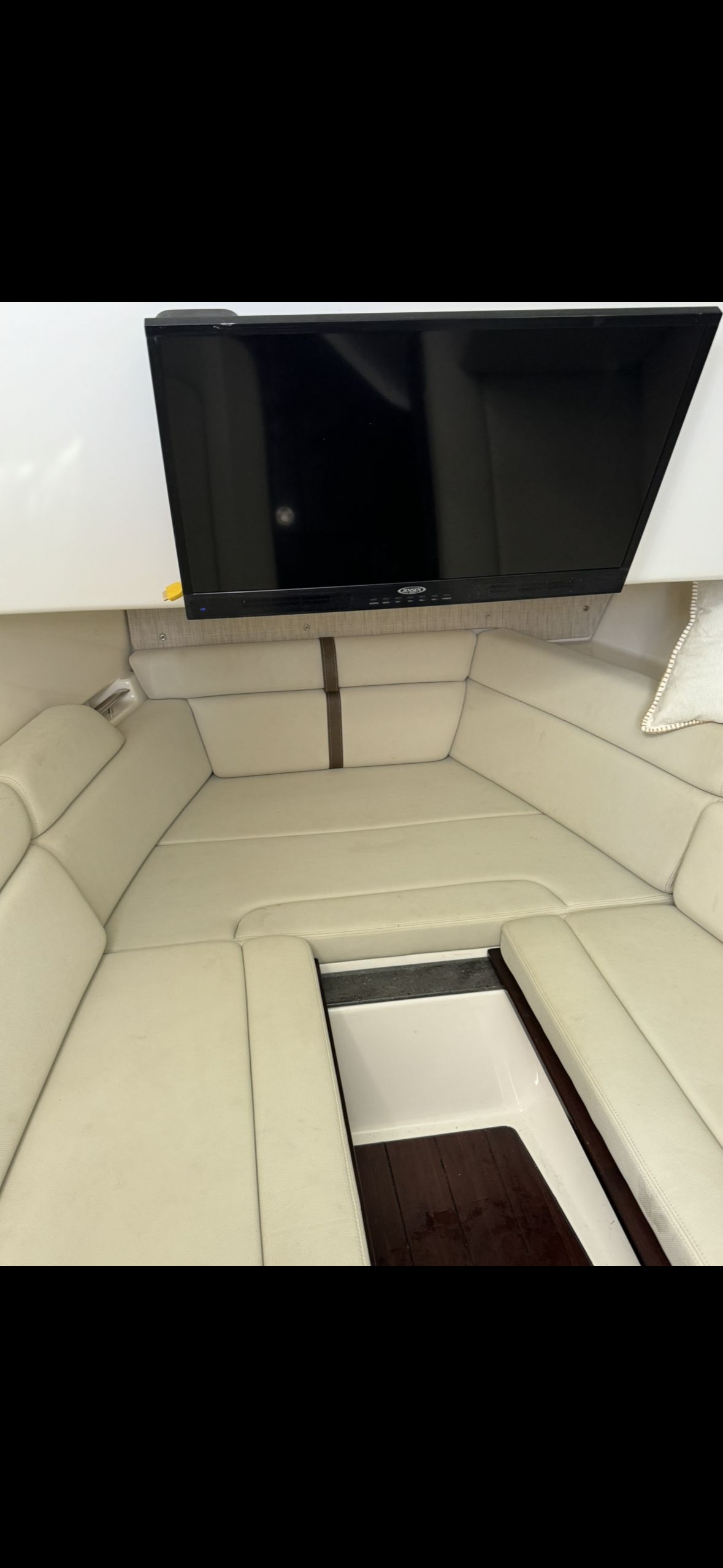 Interior of 2020 Boston Whaler 350 Realm with beige sofa and TV.