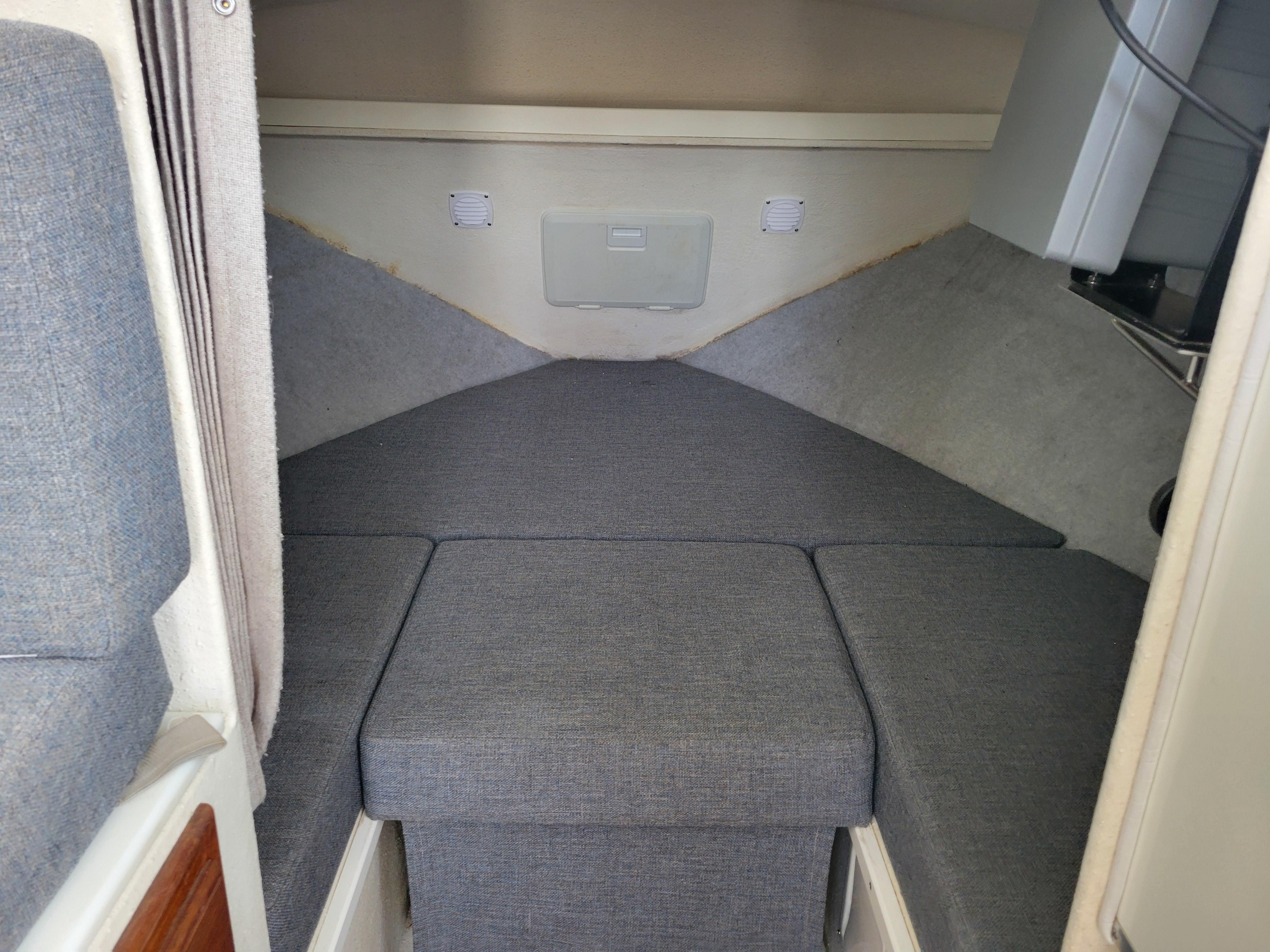 1999 SeaSport 2400 XL Limited cabin interior with gray cushioned seating.
