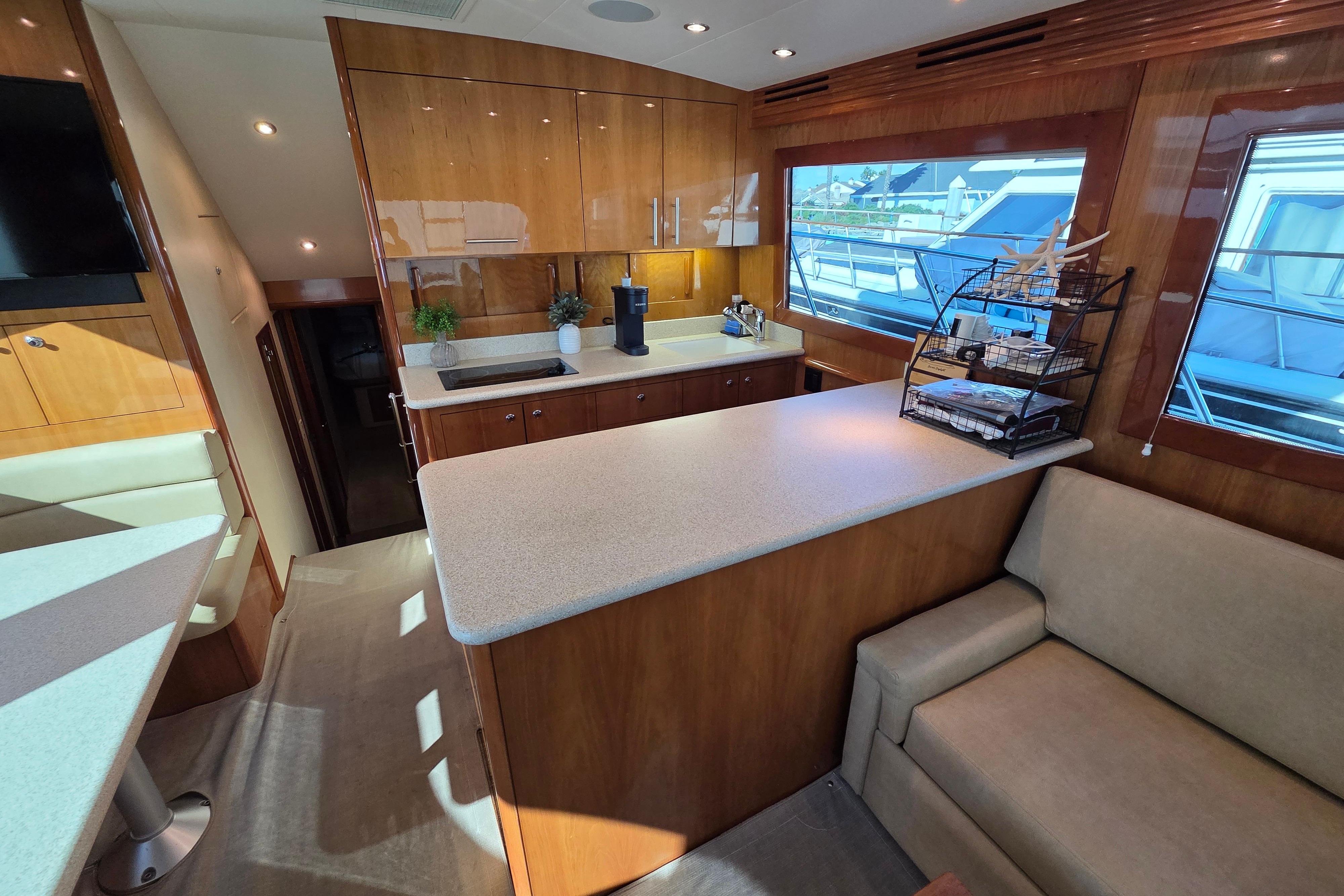 Luxurious interior of 2006 Hatteras 50 Convertible yacht with modern kitchen and seating area.
