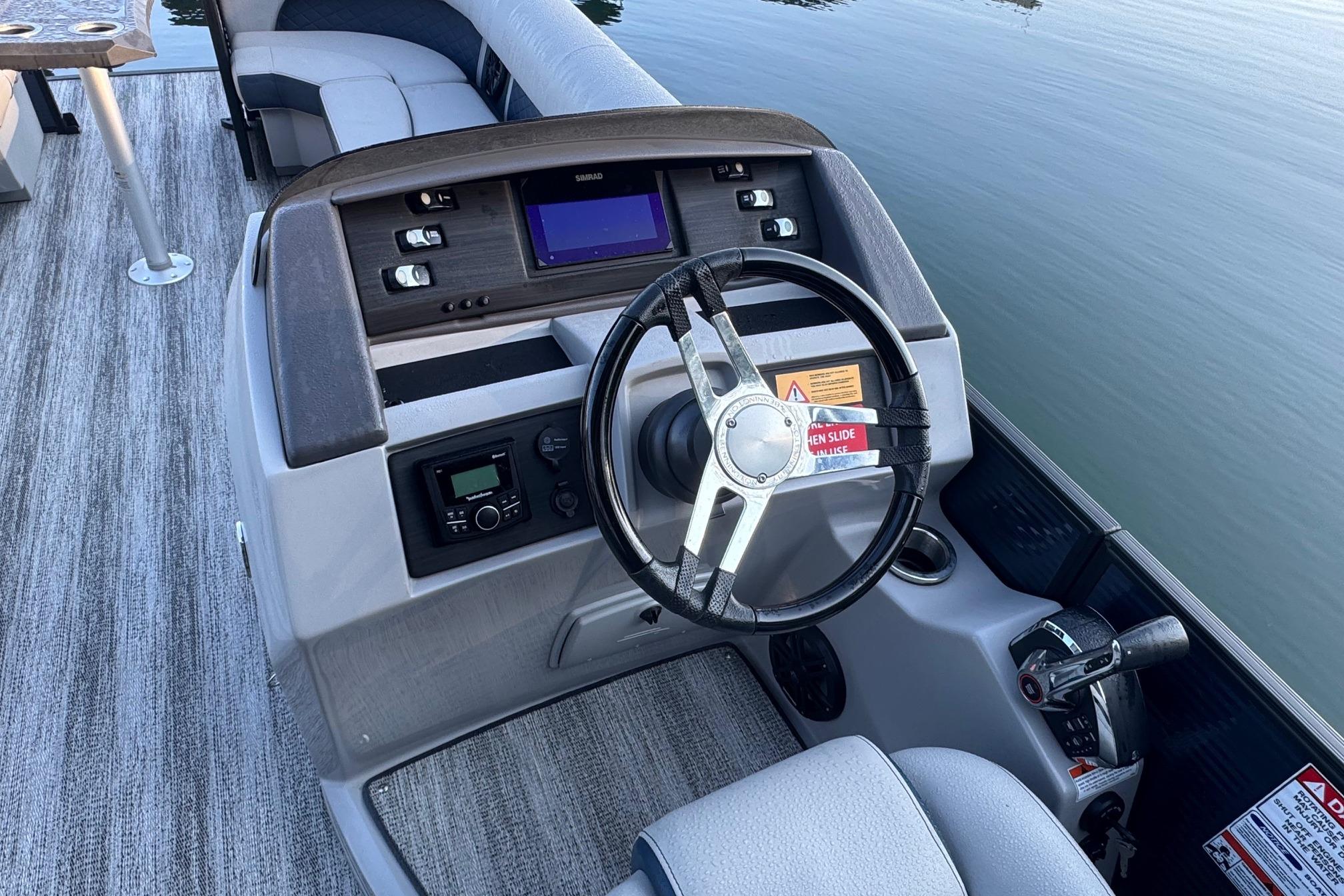 2025 Bennington 26 L Top Deck boat interior with steering wheel and control panel.